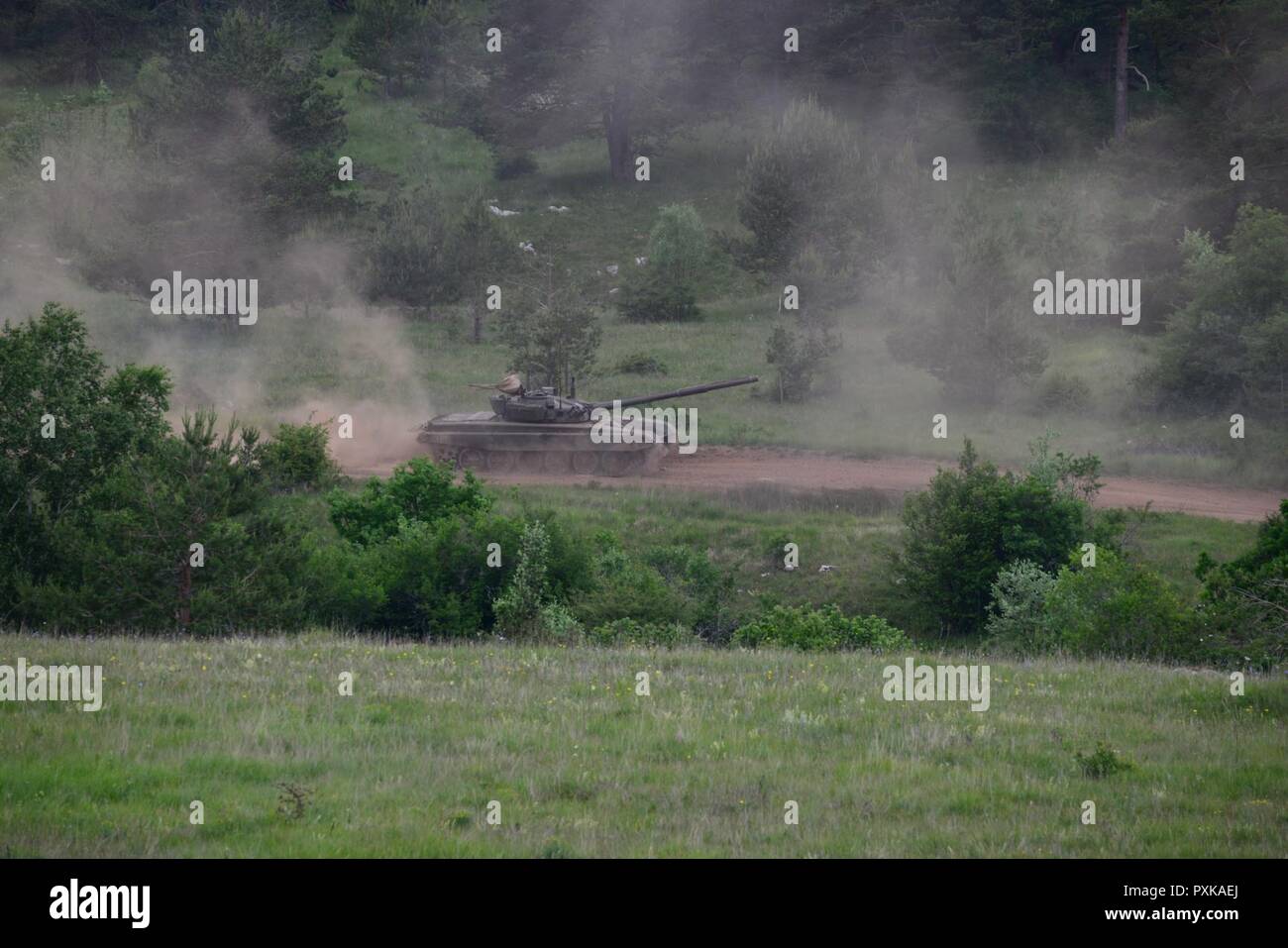 Slovenian M84 tank fires on targets called in by paratroopers from the NATO allies during a call for fire for Exercise Adriatic Strike at Pocek Range in Postonja, Slovenia, June 6, 2017. This training gives U.S. joint terminal attack controllers the chance to work directly with the militaries of other partner nations. The exercise brought together NATO allies from the U.S. and Slovenian militaries to rehearse critical skills in support of ground operations Stock Photo