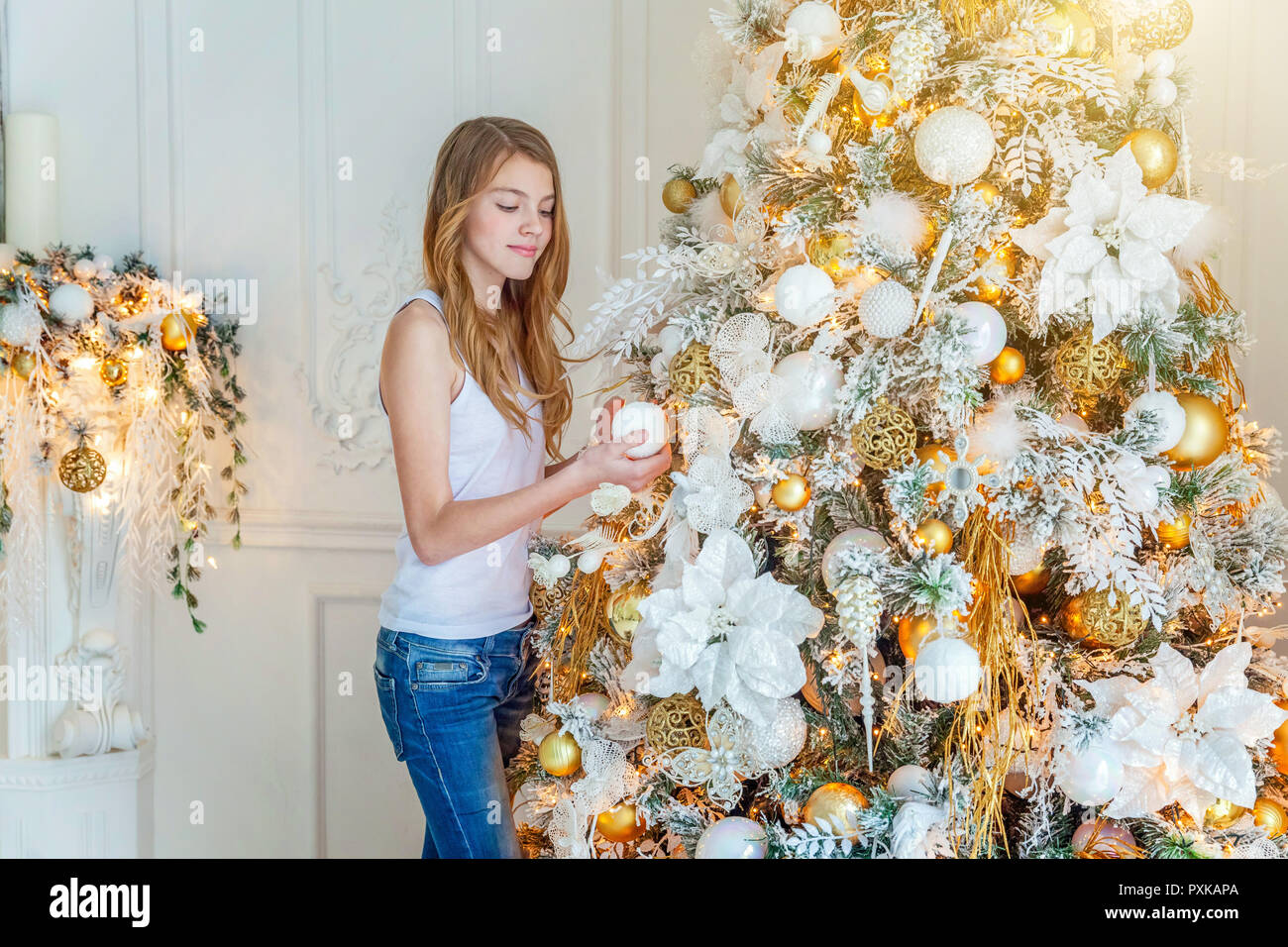 Teenage Girl Decorating Christmas Tree On Christmas Eve At