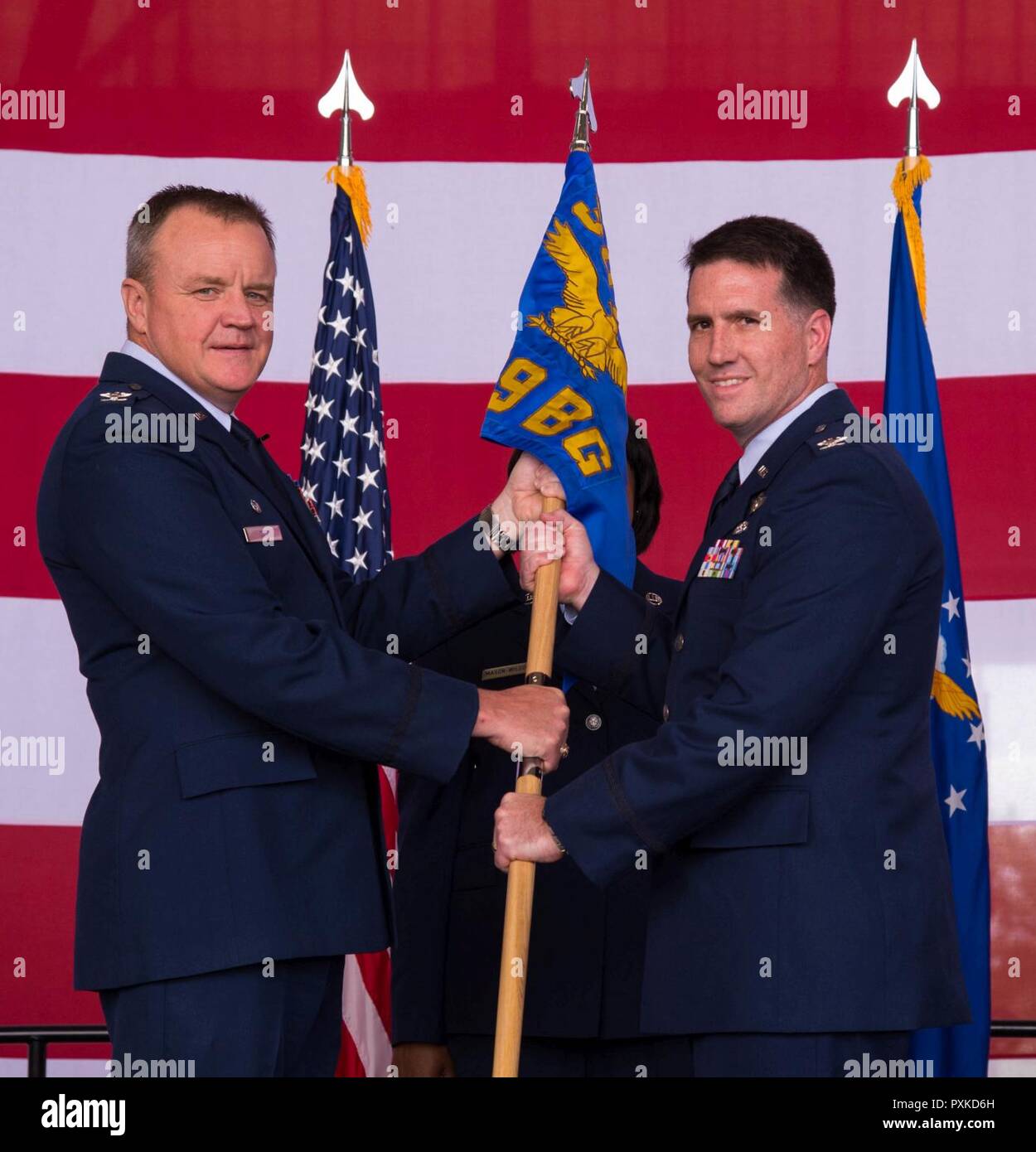 Col. Bruce Cox, 307th Bomb Wing commander, presents the guidon of the 489th Bomb Group to Col