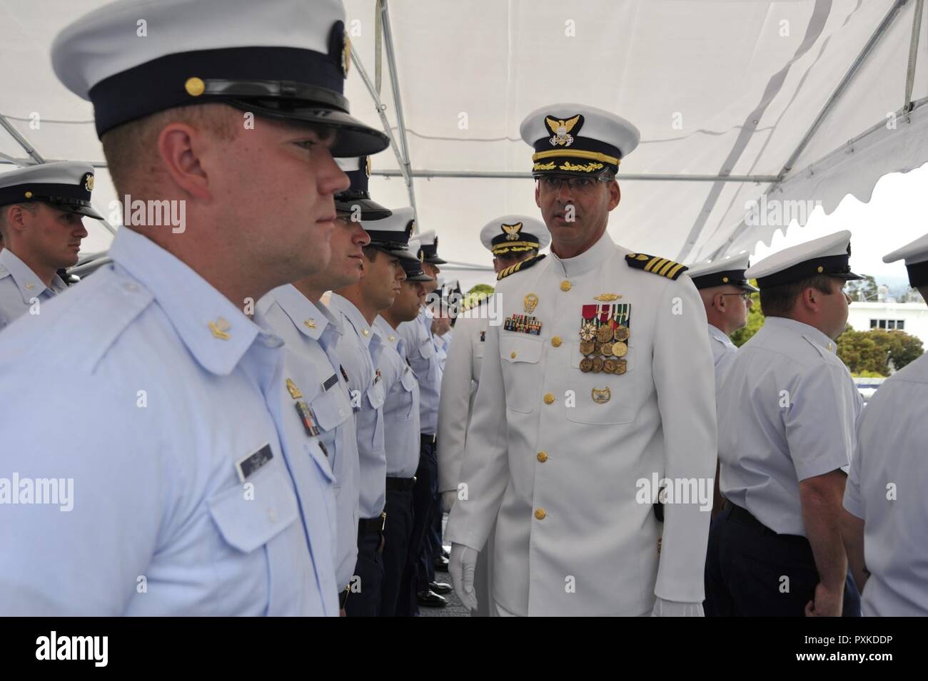 Coast Guard Capt. Nathan Moore (front) and Capt. Craig Wieschhorster conduct a personnel inspection of the crewmembers aboard the Coast Guard Cutter Stratton during a change of command ceremony in Alameda, Calif., June 8, 2017. Crewmembers aboard Stratton, a 418-foot National Security Cutter homeported in Alameda, seized or disrupted the transit of 66,000 pounds of cocaine valued at $1 billion and facilitated the apprehension of 50 suspected drug smugglers under Moore’s command from 2015 - 2017. Stock Photo