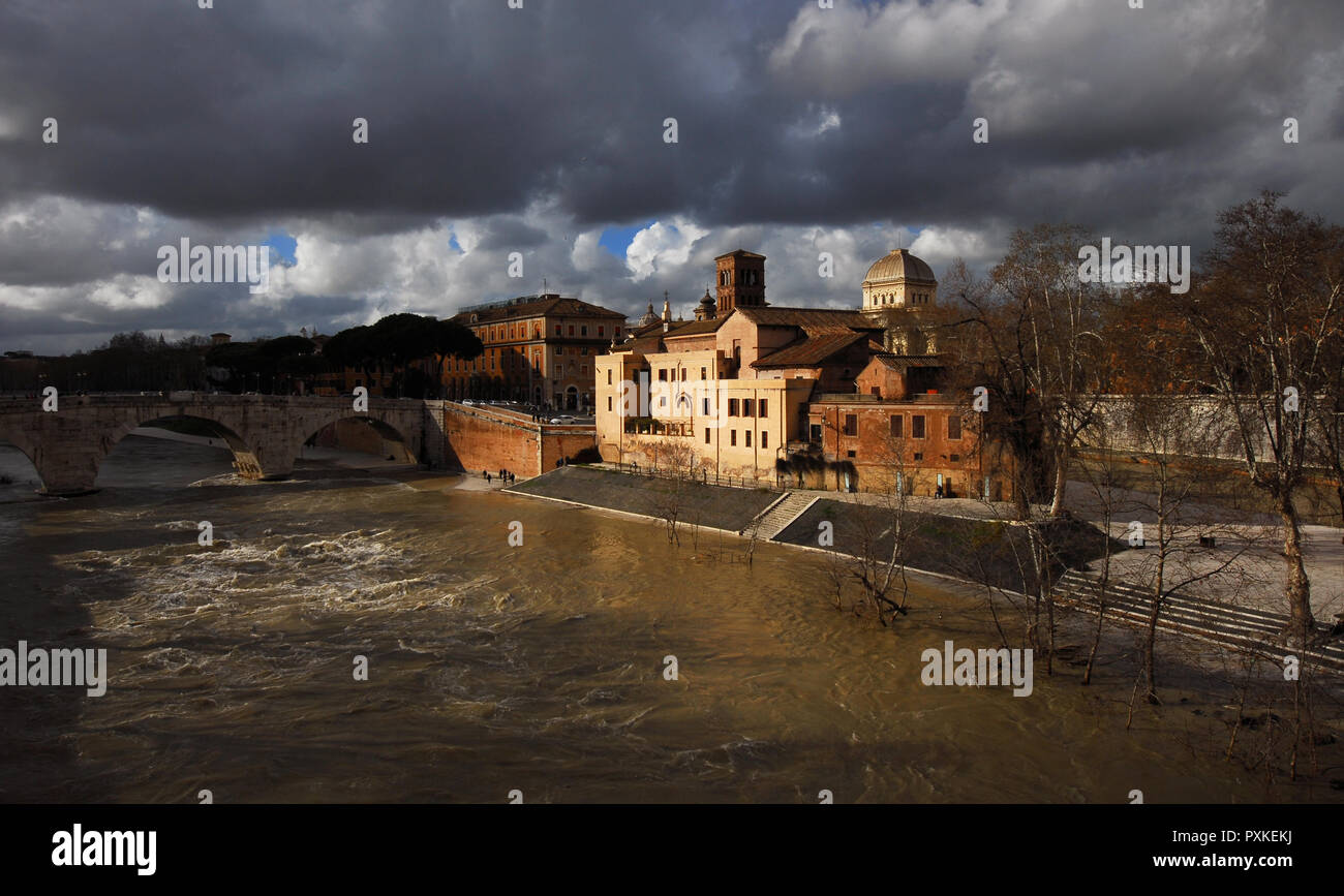 Winter in Rome. River is swollen along Tiber Island embankments under stormy clouds Stock Photo