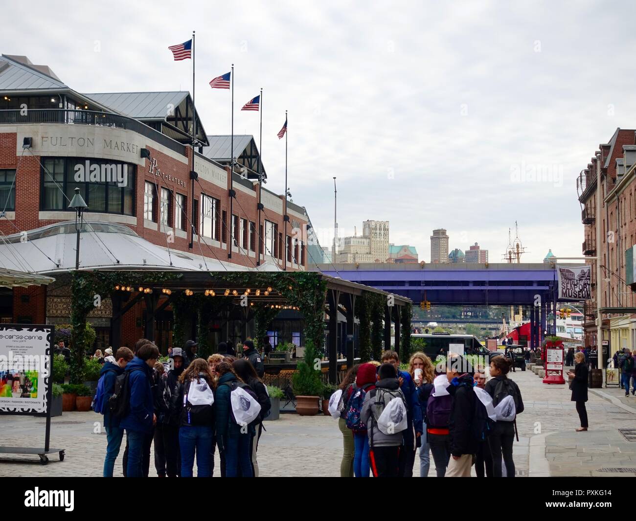 Groups of teenage students, standing in front of shops, on a trip to the South Street Seaport District, Lower Manhattan, New York, NY, USA. Stock Photo