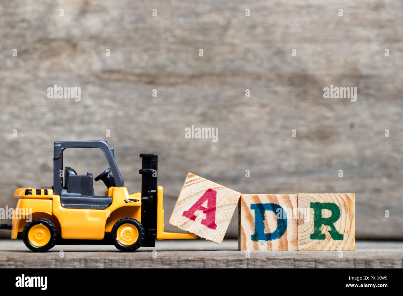 Yellow Plastic Forklift Hold Letter A To Complete Word ADR Abbreviation Of Adverse Drug 