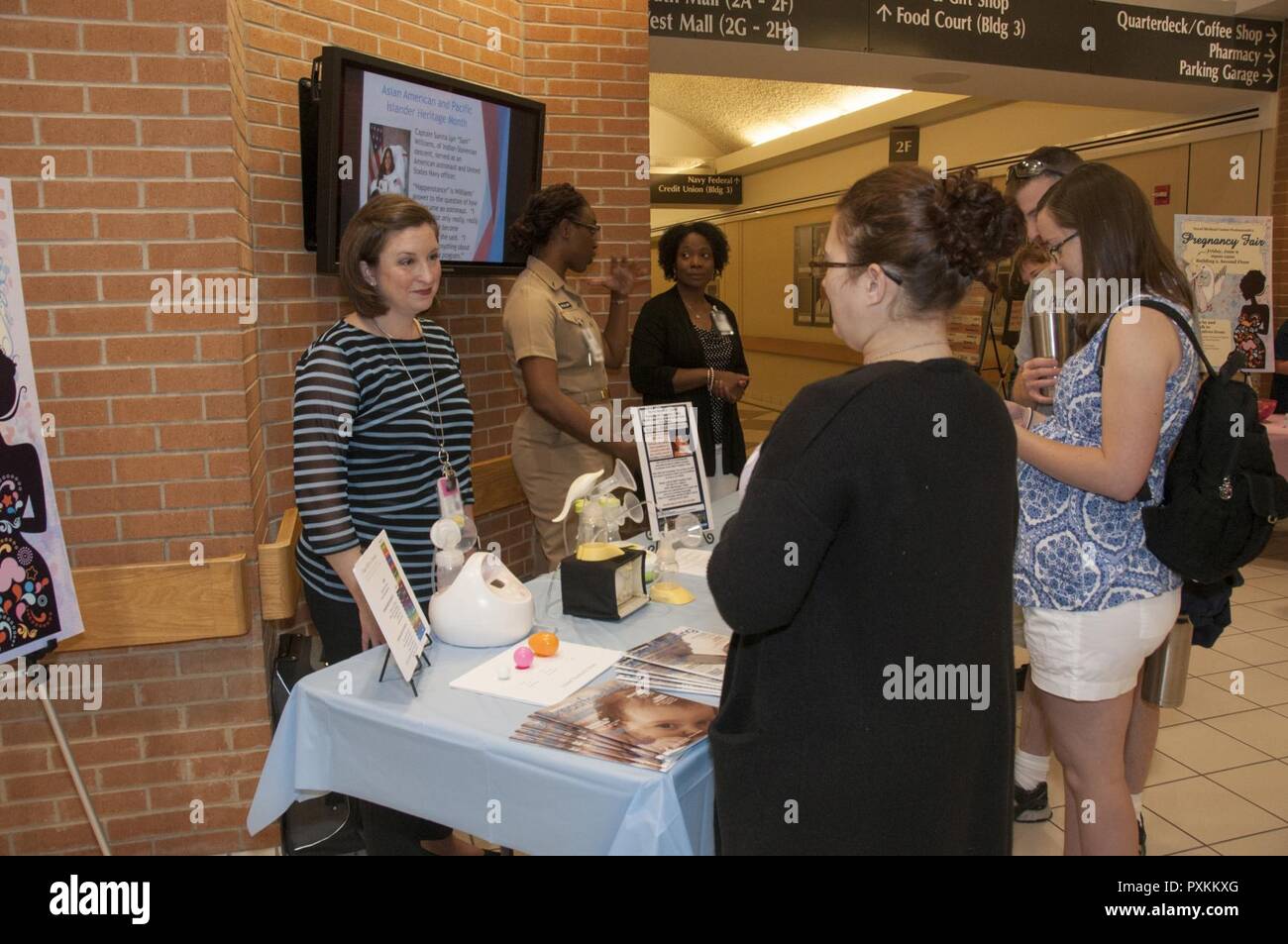 Portsmouth, Va. (June 9, 2017) Heather McFarland, left, an outpatient lactation consultant with the Pediatrics Clinic, speaks with a patient about lactation consultant services during the Pregnancy Fair at Naval Medical Center Portsmouth. The Women’s Health Clinic sponsored the fair that offered information on a variety of pregnancy-related topics, including nutrition, exercise, fetal development, birthing positions and lactation. Stock Photo