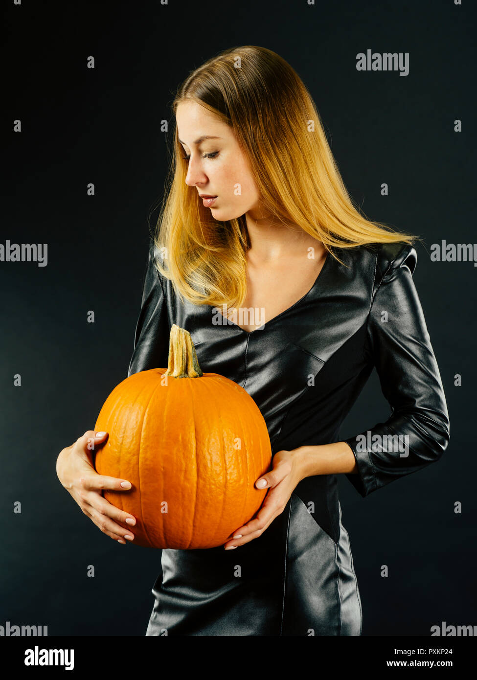 Photo of a young sexy woman holding a pumpkin over smoky dark background  for Halloween Stock Photo - Alamy