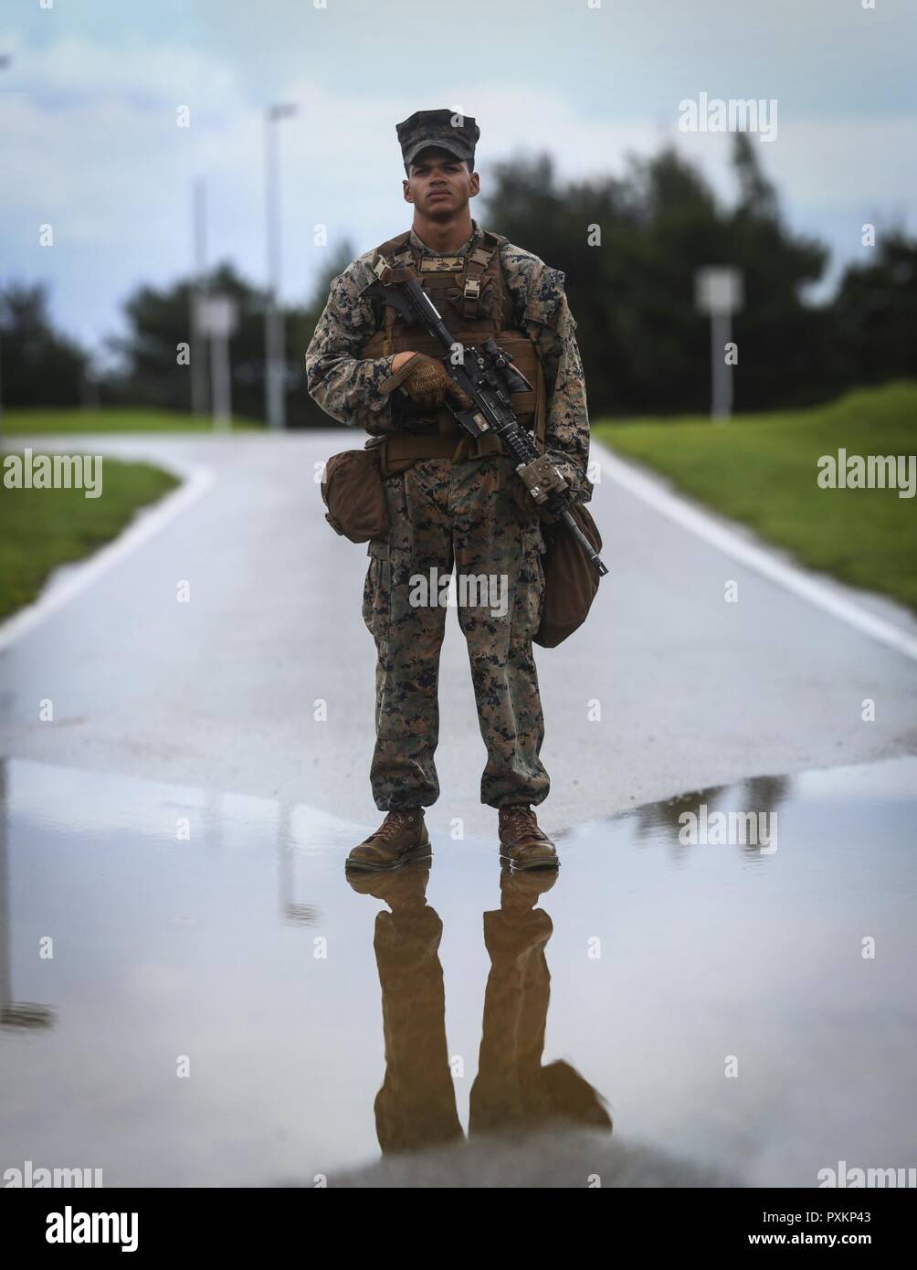 Lance Cpl. James J. Beck, a rifleman assigned to Alpha Company, 1st Battalion, 3rd Marine Regiment, poses for a portrait prior to conducting Battlesight Zero on his M4A1 carbine at Range 1 aboard Camp Hansen, Okinawa, Japan, June 14, 2017. The Hawaii-based battalion is forward deployed to Okinawa, Japan as part of the Unit Deployment Program. Stock Photo