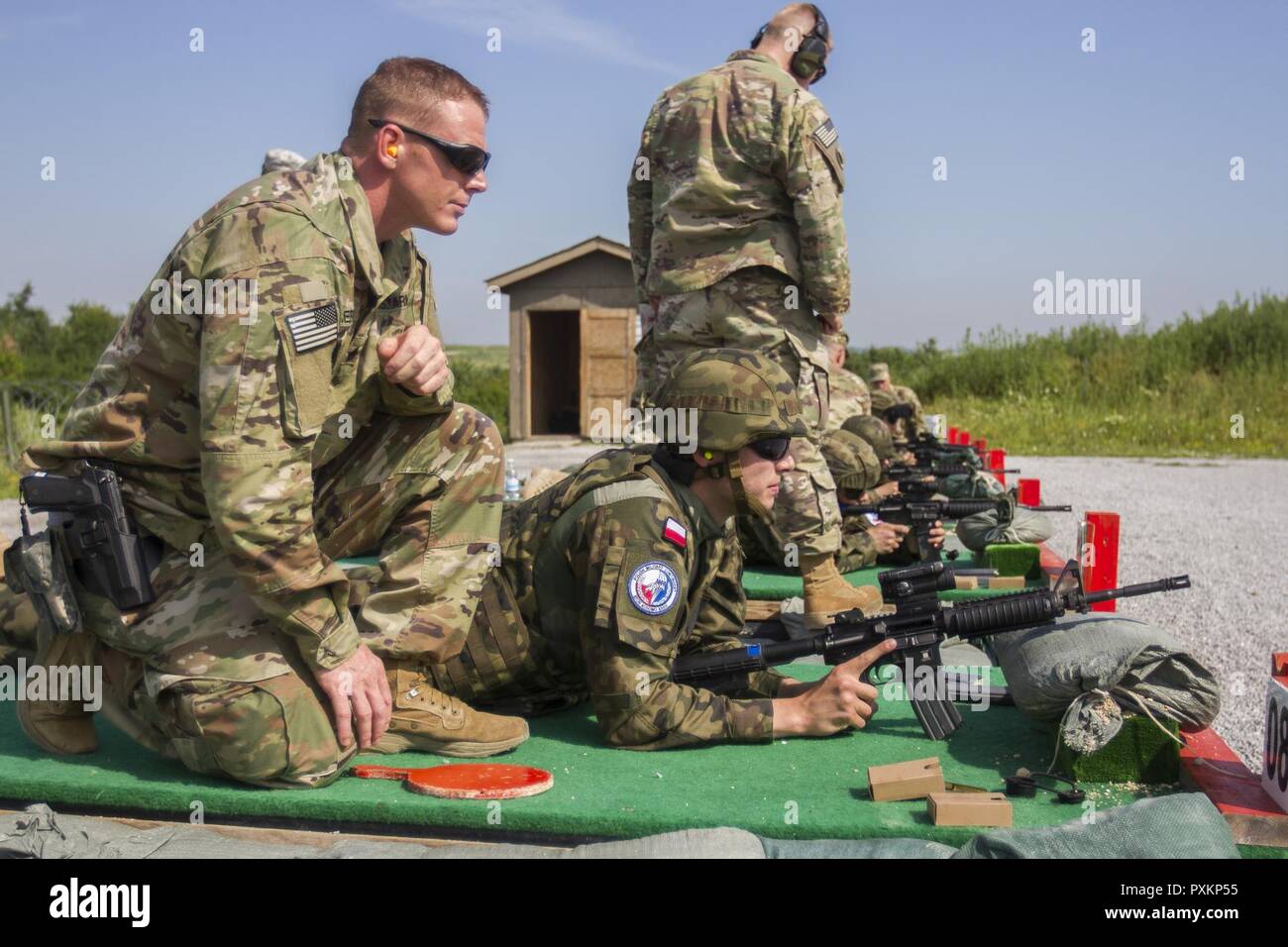 U.S. Army Soldiers, assigned to Multinational Battle Group-East, host a qualification range for multinational soldiers assigned to Kosovo Force, on Camp Bondsteel, Kosovo, June 16. The range helped familiarize multinational KFOR soldiers with the handling procedures of an M4-A1 rifle. Stock Photo