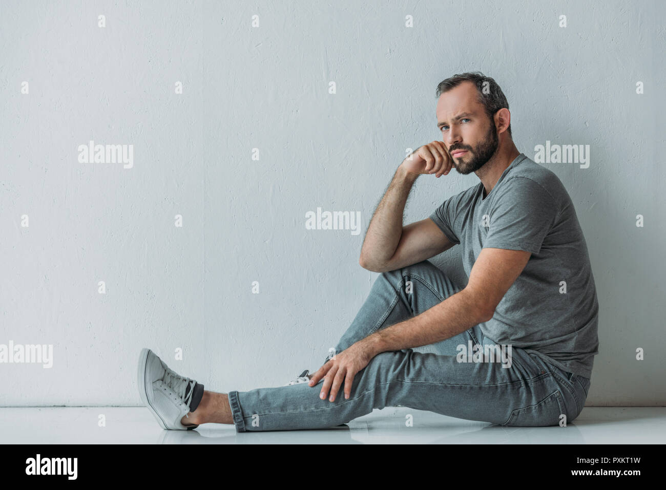 мужик сидит на полу. парень сидит на полу. мужик сидит на полу. человек сидит на полу. мужчина сидит на полу.