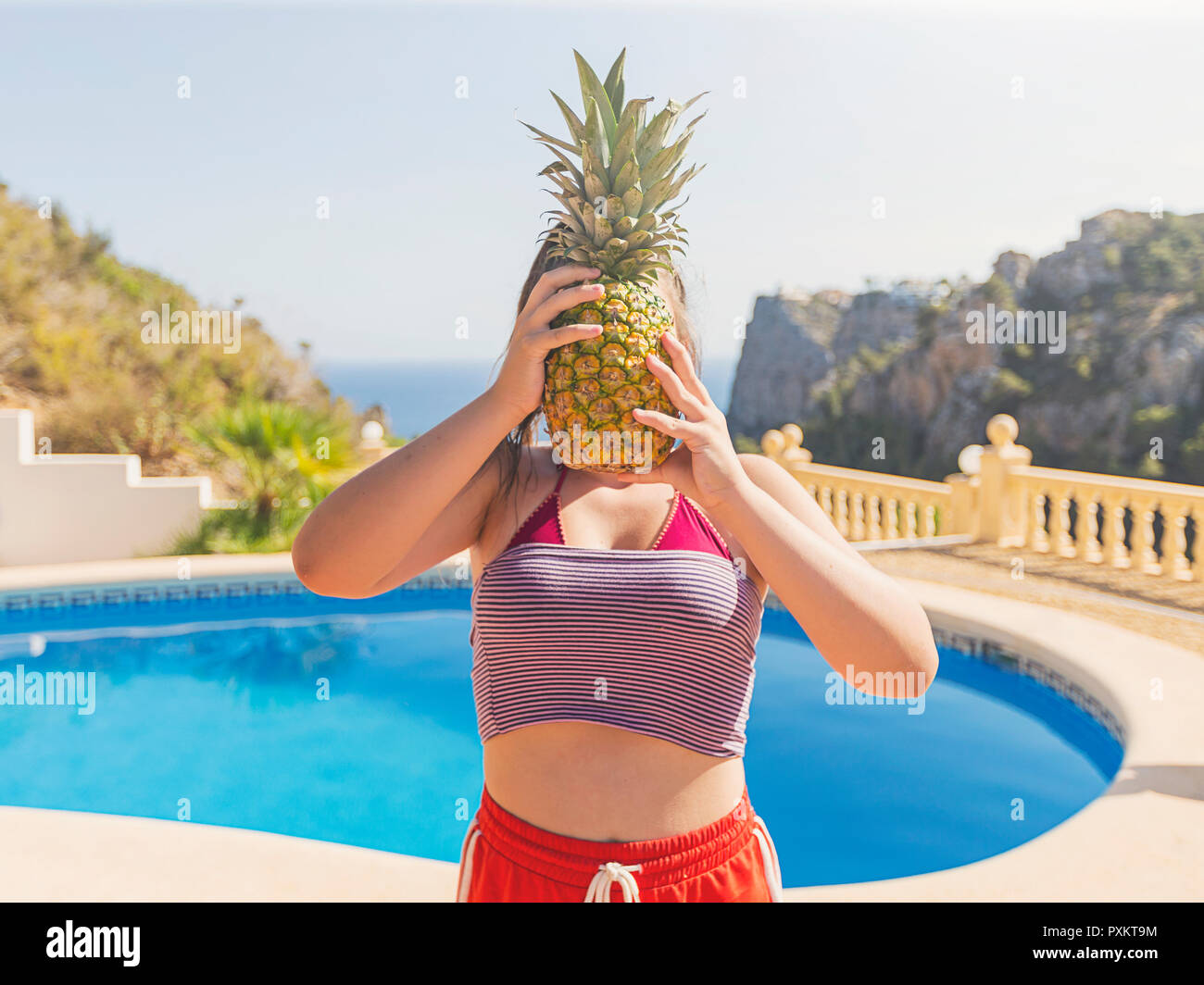 Girl with pineapple covering face Stock Photo