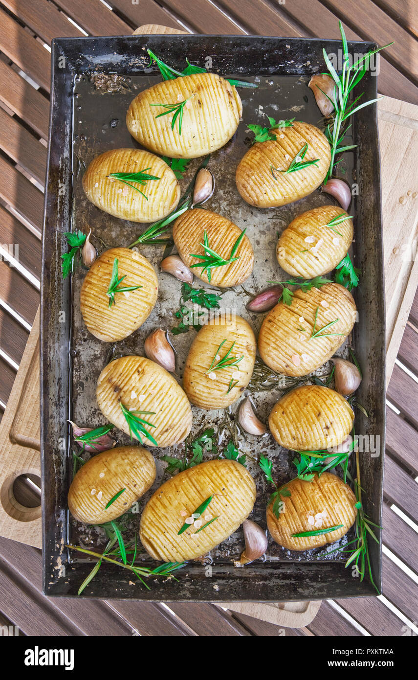 Homemade cheesy Hasselback potatoes. Vegetarian food Stock Photo