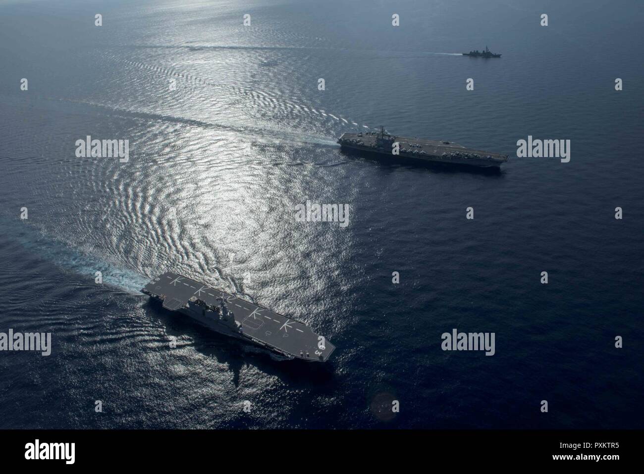 9 SOUTH CHINA SEA (June 15, 2017) The Nimitz-class aircraft carrier, USS Ronald Reagan (CVN 76), Izumo-class helicopter destroyer, JS Izumo (DDH 183), and Takanami-class destroyer JS Sazanami (DDG 113), sail in formation during a combined Japan Maritime Self-Defense Force and U.S. Navy exercise June 13-15, 2017. Participants included USS Ronald Reagan, the Ticonderoga-class guided-missile cruiser USS Shiloh (CG 67), Carrier Air Wing 5, Destroyer Squadron 15, the Arleigh Burke-class guided-missile destroyers USS Barry (DDG 52) and USS McCampbell (DDG 85), JS Izumo and JS Sazanami. The Japan Mar Stock Photo