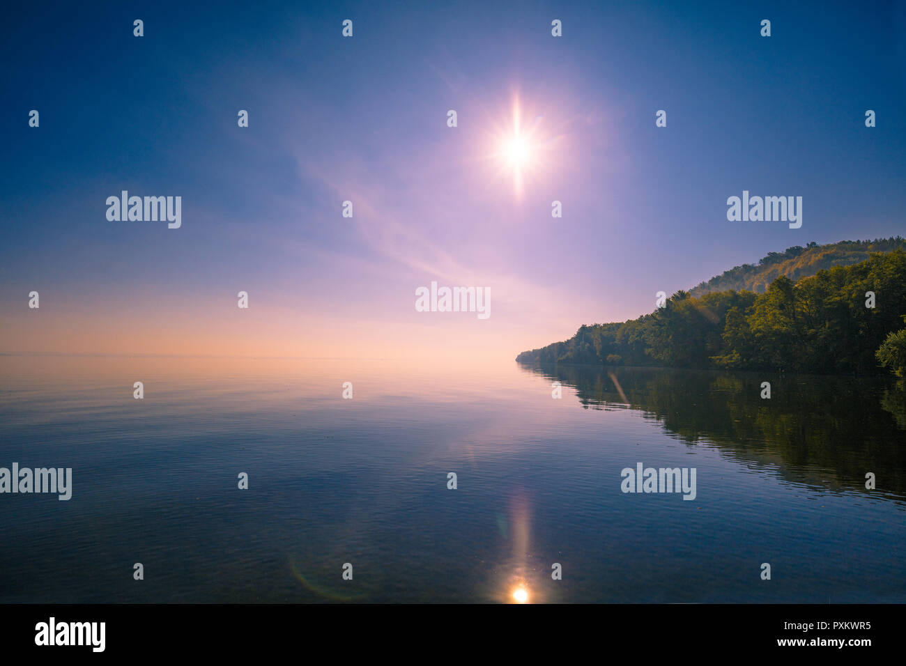 Cape in a calm sea on a foggy autumn morning Stock Photo