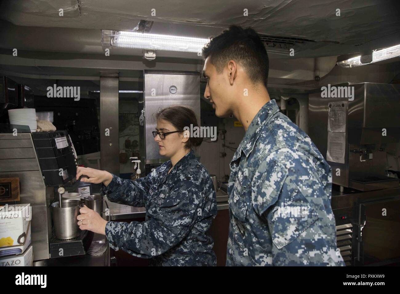 NORFOLK, Va. (June 8, 2017) Ship's Serviceman Seaman Brianna Whitman, left, from Kingsford, Mich., teaches Gunner's Mate 3rd Class Adrian Mora, from Modesto, Calif., how to make coffee in the coffeehouse aboard the aircraft carrier USS Dwight D. Eisenhower (CVN 69) (Ike). Ike is pier side during the sustainment phase of the Optimized Fleet Response Plan (OFRP). Stock Photo