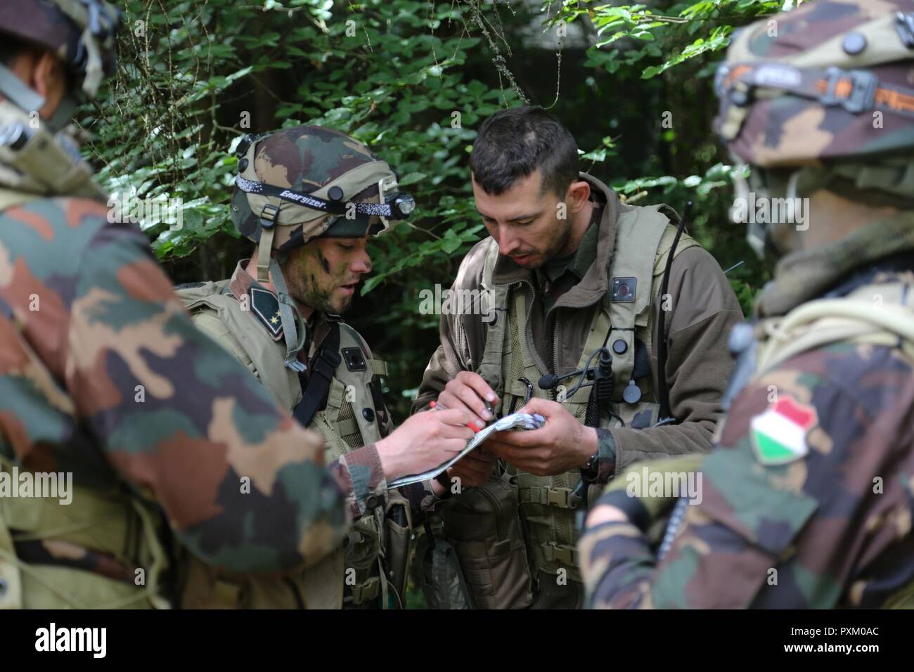 Hungarian soldiers of 3rd Bercsenyi Miklos Infantry Battalion brief mission details while conducting base defense operations during Exercise Combined Resolve VIII at the Hohenfels Training Area, Hohenfels, Germany, June 8, 2017. Exercise Combined Resolve VIII is a multinational exercise designed to train the Army’s Regionally Allocated Forces to the U.S. European Command. Combined Resolve VIII will include more than 3,400 participants from 10 nations. The goal of the exercise is to prepare forces in Europe to operate together to promote stability and security in the region. Stock Photo