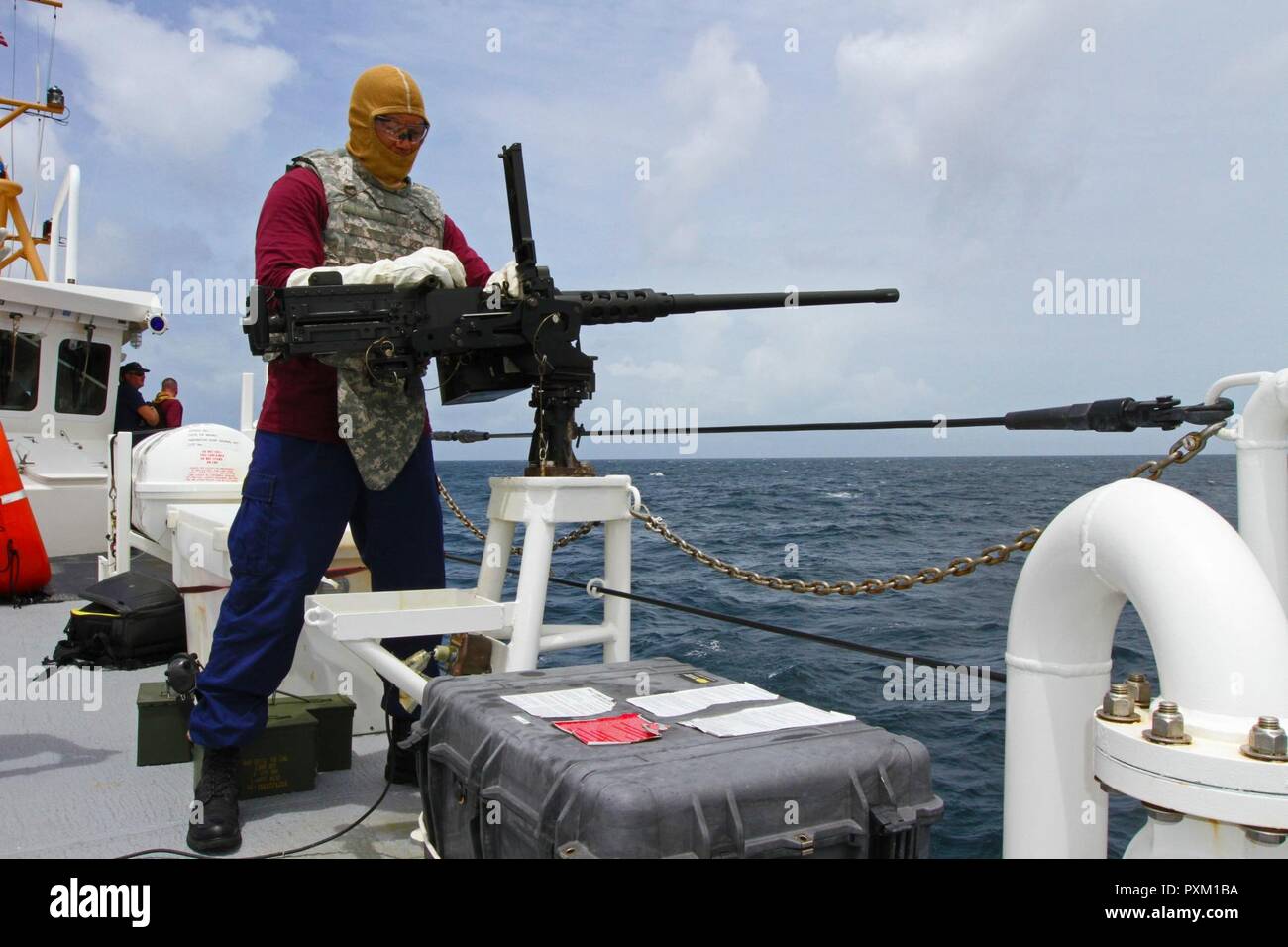 U.S. Coast Guard Electrician’s Technician 2nd Class John Leo, a Newport News, Virginia native serving on the USCG Cutter Winslow Griesser, helps prepare a .50 caliber machine gun during Exercise Tradewinds 2017, at the Barbados Coast Guard Station, June 8, 2017. Military and civilians from 20 countries are participating in this year’s exercise in Barbados and Trinidad & Tobago, which runs from June 6-17, 2017. Stock Photo