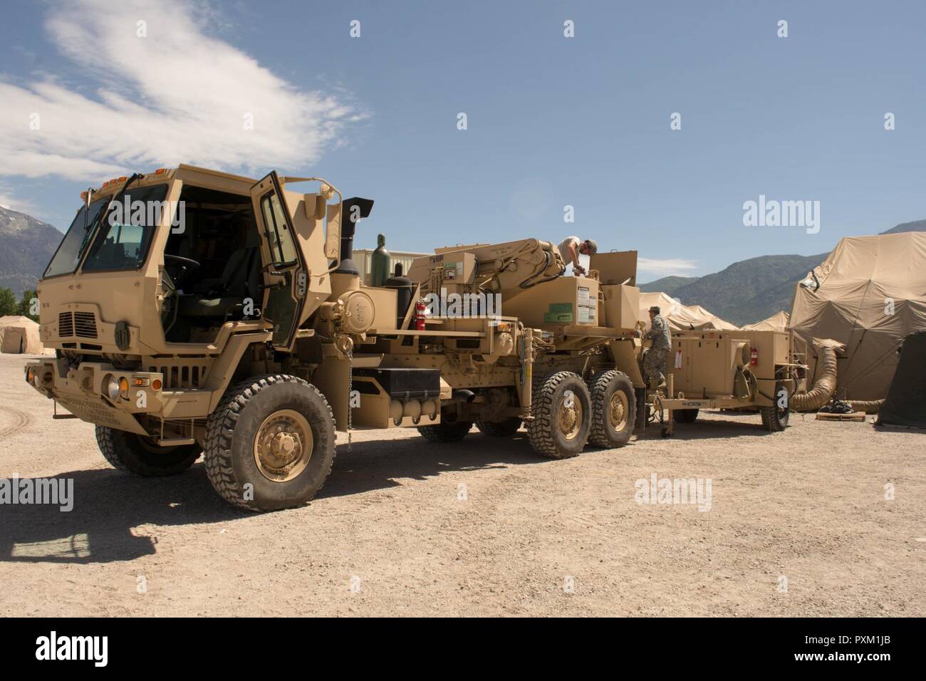 Spc. Joshua Oaks, with the 96th Sustainment Brigade Headquarters and Headquarters Company, adjusts a glad hand of a Family of Medium Tactical Vehicle 5-ton wrecker during Operation Sustain Fury in Ogden, Utah, June 10, 2017. FMTV wreckers are often used to recovery military vehicles. Stock Photo