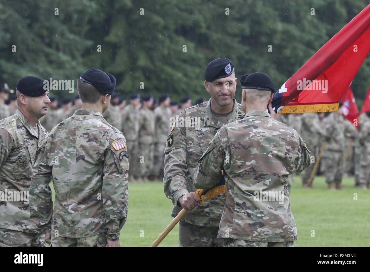 Col. David Foley hands the 1-2 Stryker Brigade Combat Team colors to Maj. Gen. Thomas James, the 7th Infantry Division commander, as he relinquishes command of the Ghost Brigade June 8, 2017, at Joint Base Lewis-McChord, Wash. The 1-2 SBCT held a change of command ceremony at Watkins Field and bid farewell to outgoing commander Col. David Foley and welcomed the incoming commander Col. Jasper Jeffers. Stock Photo