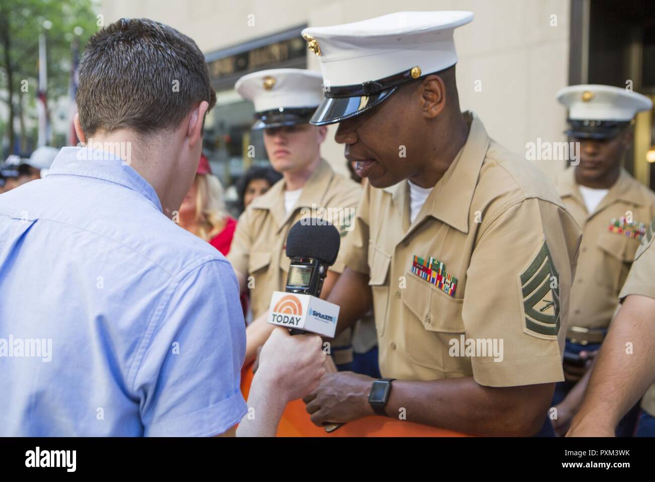 Gunnery Sgt. Justin A. Hauser, enlisted conductor of Marine Corps Band New Orleans, talks with Alex Ficquette, the Rockefeller plaza producer, during the airing of NBC’s Today Show at Rockefeller Center in New York, June 12, 2017. Hauser spoke about the numerous concerts the band is scheduled to perform June 14-16 to celebrate the closing of the yearlong Marine Corps Reserve Centennial celebration. Stock Photo