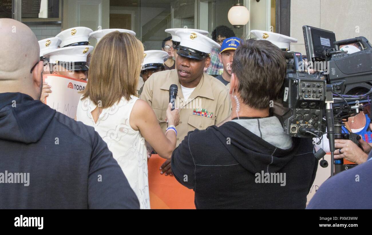 Gunnery Sgt. Justin A. Hauser, enlisted conductor of Marine Corps Band New Orleans, speaks with Hoda Kotb, co-host of NBC's Today Show, at the Rockefeller Center in New York, June 12, 2017. Hauser spoke live with Kotb to promote the multiple Marine Corps Reserve Centennial concerts the band will perform around New York. Stock Photo