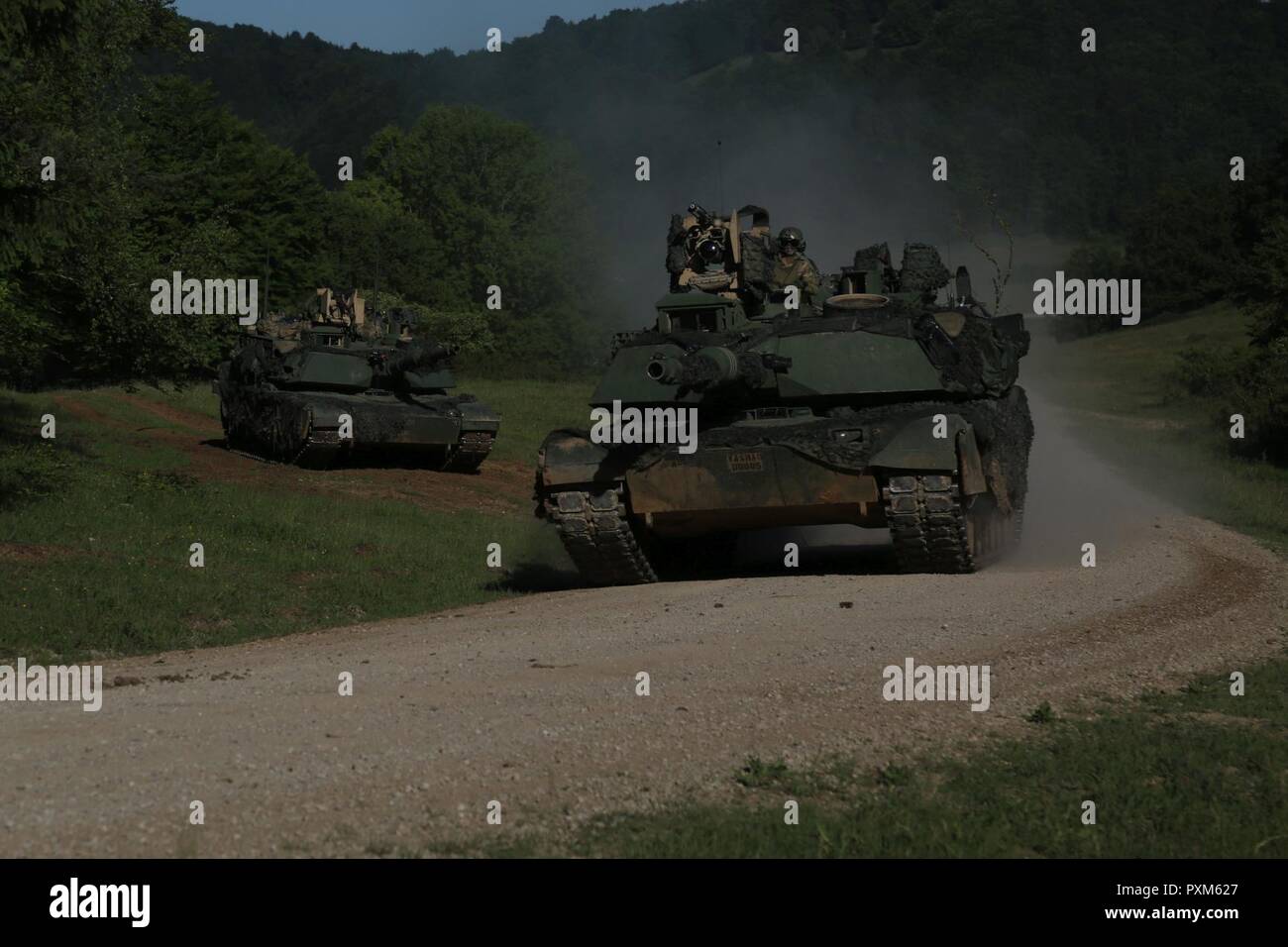 U.S. Soldiers of Ares Company, 166th Armored Regiment, 4th Infantry Division bound with M1A2 Abrams Main Battle Tanks while conducting a tactical movement during Exercise Combined Resolve VIII at the Hohenfels Training Area, Hohenfels, Germany, June 9, 2017. Exercise Combined Resolve VIII is a multinational exercise designed to train the Army’s Regionally Allocated Forces to the U.S. European Command. Combined Resolve VIII will include more than 3,400 participants from 10 nations. The goal of the exercise is to prepare forces in Europe to operate together to promote stability and security in t Stock Photo