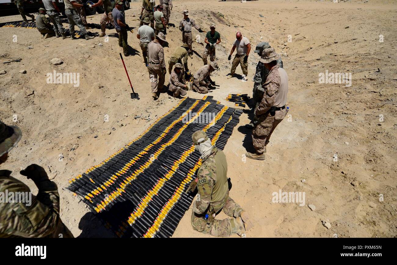 U.S. Air Force, U.S. Marine Corps and coalition partners assigned to the 407th Air Expeditionary Group prepare more than 5,000 pieces of unserviceable 30mm rounds and aircraft decoy flares for a coordinated detonation at the bomb range in Southwest Asia on June 6, 2017. Explosive ordnance disposal technicians are charged with locating, identifying, disarming, neutralizing, recovering, and disposing of hazardous explosives; conventional, chemical, biological, incendiary, and nuclear ordnance; and criminal or terrorist devices. Stock Photo