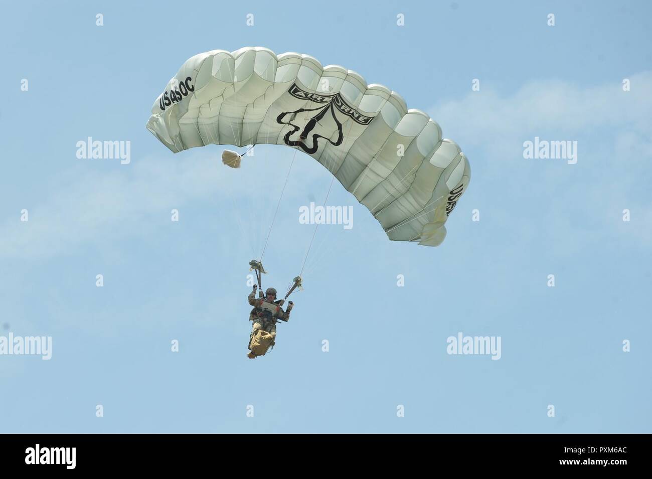 A member of the Black Daggers, the official U.S. Army Special Operations Command Parachute Demonstration Team, performs aerial stunts during Scott Air Force Base 2017 Air Show and Open House June 10, which celebrates the base’s 100th anniversary.  The black daggers use the military variant of the ram-air parachute, which is a flexible-wing glider.  This allows a free-fall parachutist the ability to jump with more than 100 pounds of additional equipment. Stock Photo