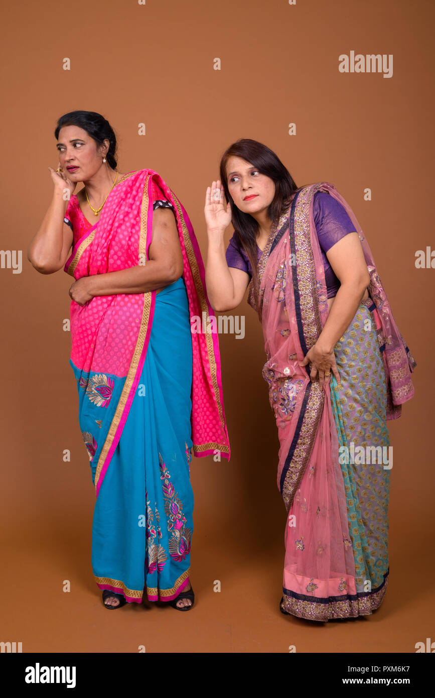 Portrait of two mature Indian women listening gossip Stock Photo