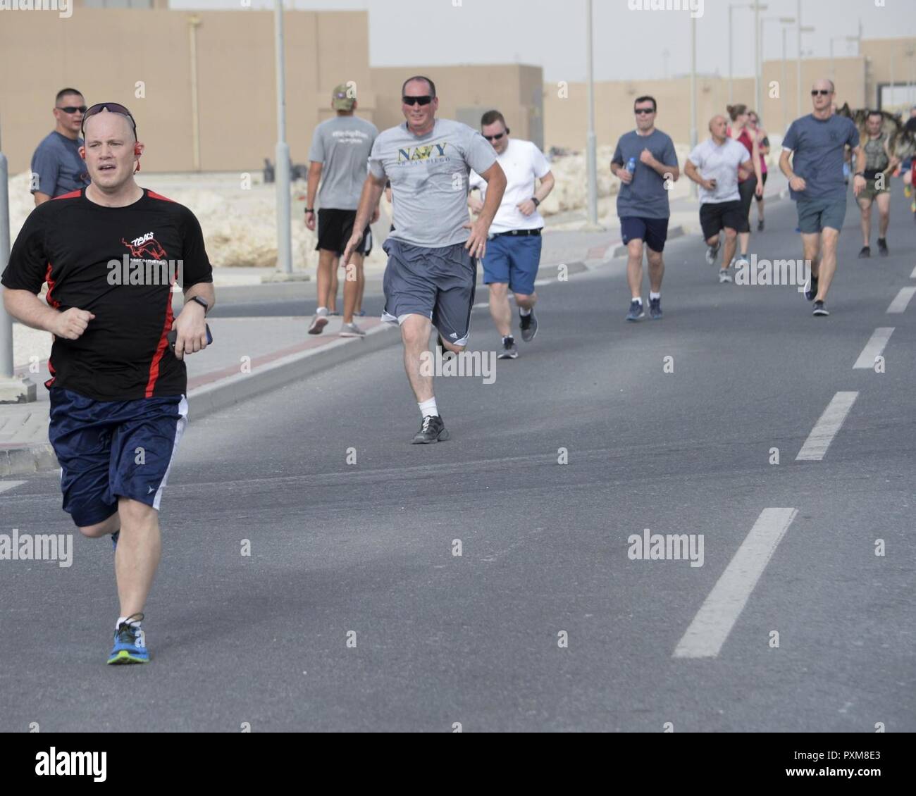 Military members participate in the annual Explosive Ordinance Disposal 5K Memorial Run at Al Udeid Air Base, Qatar, June 3, 2017. Service members from across the base gathered to take part in the EOD 5K Memorial Run in memory of the EOD men and women killed in action during combat operations. Stock Photo