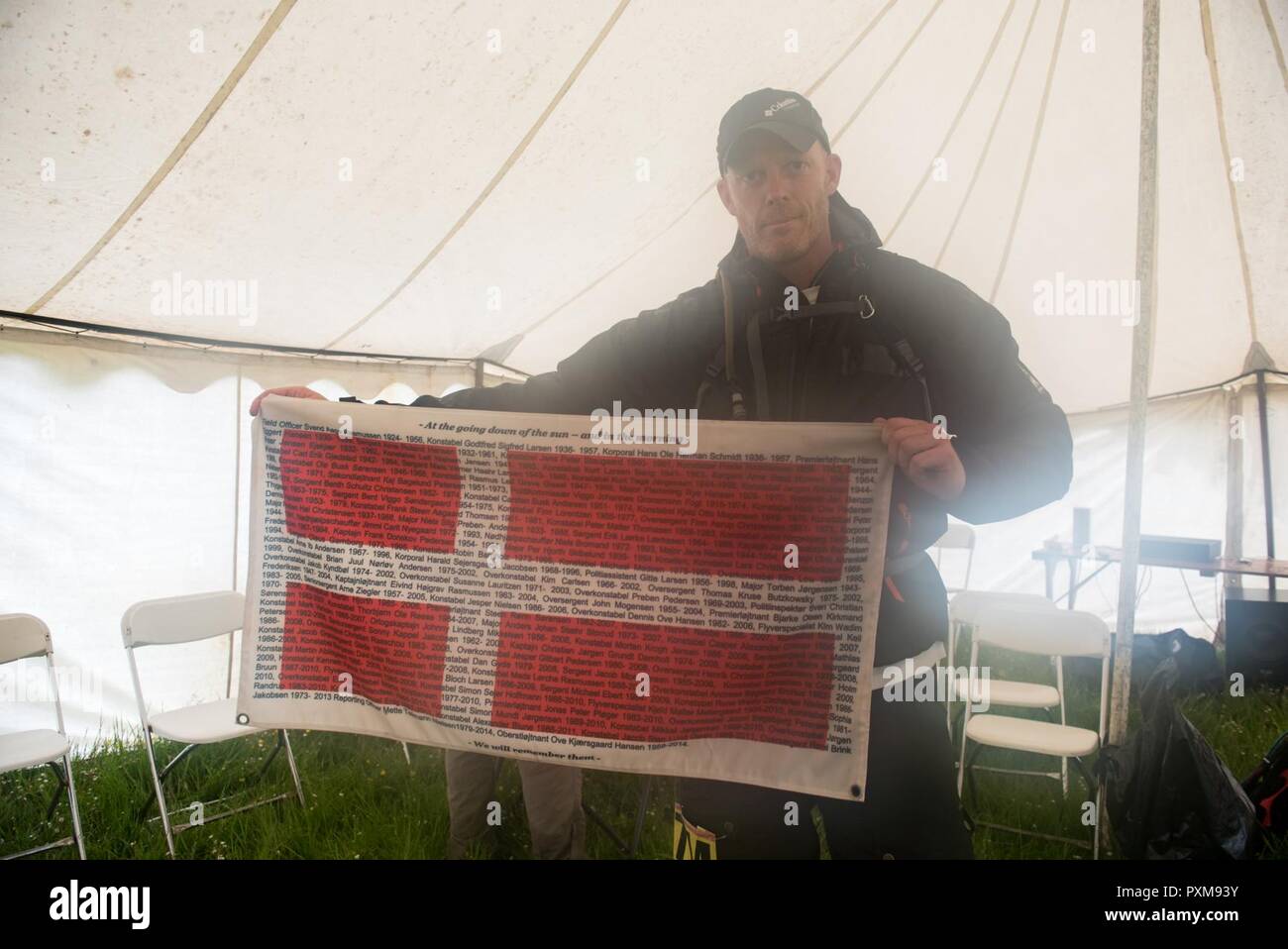 A Former Danish Service Member Holds A Flag With The Names Of