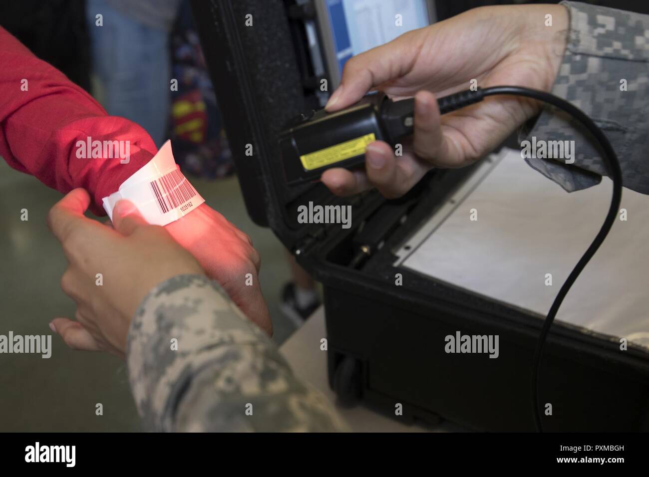U.S. Army Specialist Brianna Doo, U.S. Army in Japan band, scans a bracelet with a Noncombatant Evacuation Operations tracking system (NTS) barcode at Yokota Air Base, Japan, during noncombatant evacuation exercise Focused Passage 2017. Eighth Army conducts NEO administrative and training tasks designed to inspect NEO packets, conduct NEO representative/warden training, NTS operator training, and account for all Department of Defense noncombatants. Stock Photo