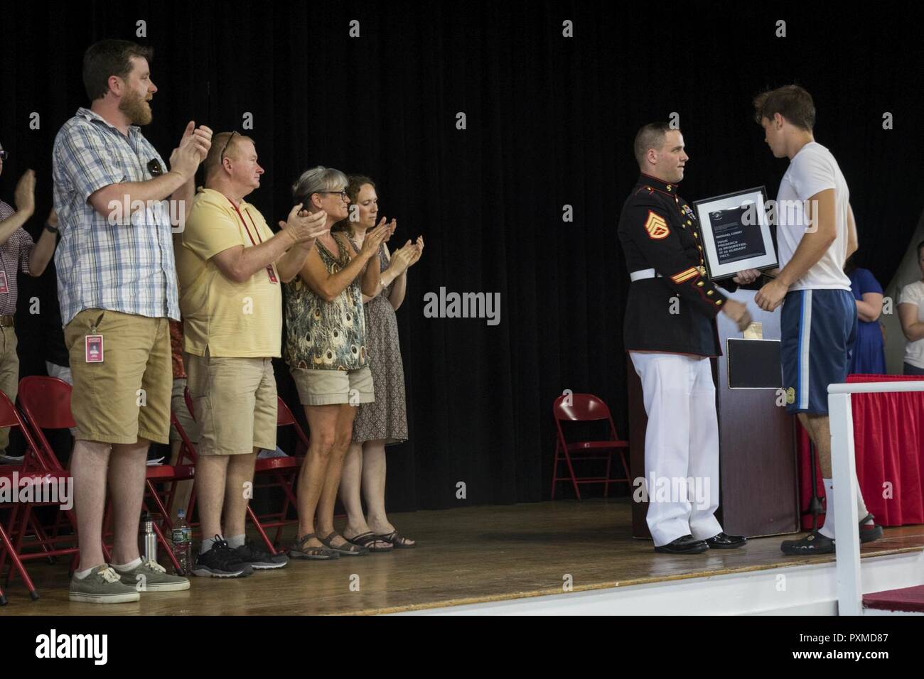 Staff Sgt. James Ralstin presents Michael Lunny, a junior with Sanford High School in Sanford, Maine, with a plaque commemorating his Semper Fidelis All-American Program selection during an award ceremony at the school, June 13, 2017. Lunny will be one of less than 100 nominees attending the Battles Won Academy, a Marine Corps leadership and networking seminar in Washington, D.C. Ralstin is a canvassing recruiter for Recruiting Substation Dover, N.H. Stock Photo