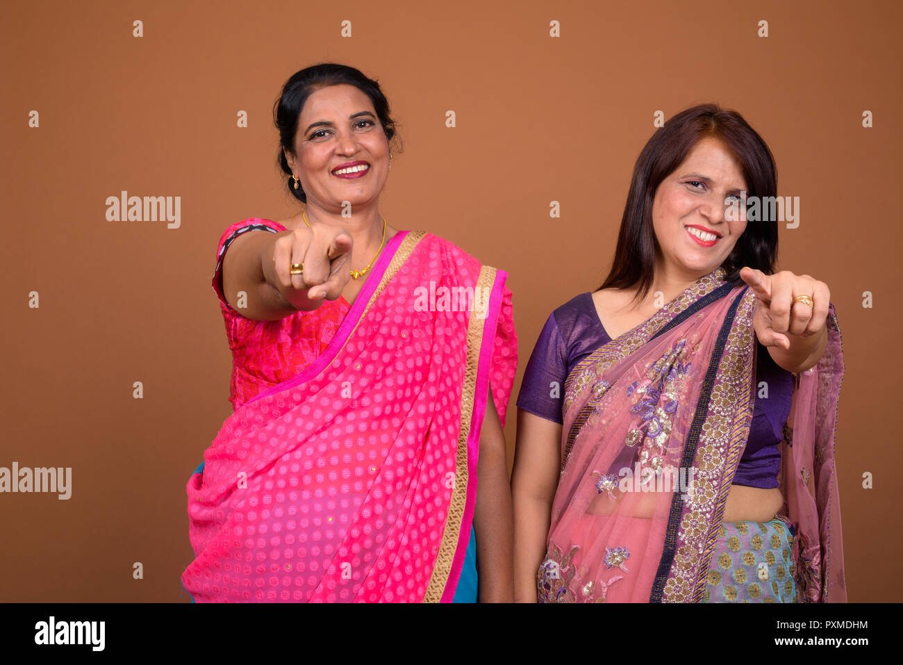 Two mature Indian women smiling and pointing finger to camera Stock Photo