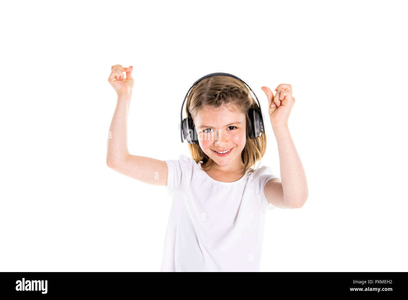 A Portrait of a cute 7 years old girl Isolated over white background with headphone Stock Photo