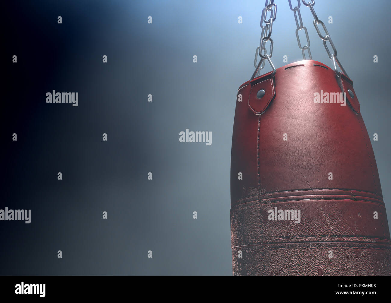 An old worn red leather punching bag hanging by chains in a  dark room lit by an ethereal spotlight - 3D render Stock Photo