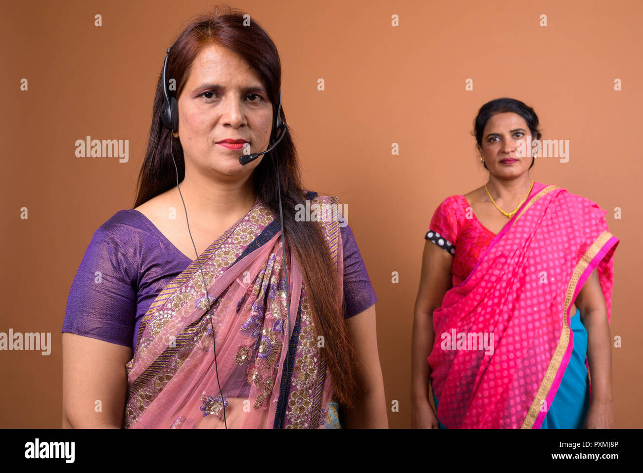 Portrait of mature Indian woman call center representative wearing headset Stock Photo