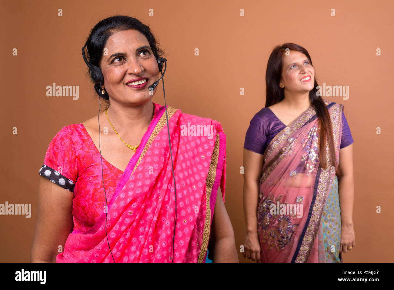 Happy mature Indian woman call center representative thinking Stock Photo