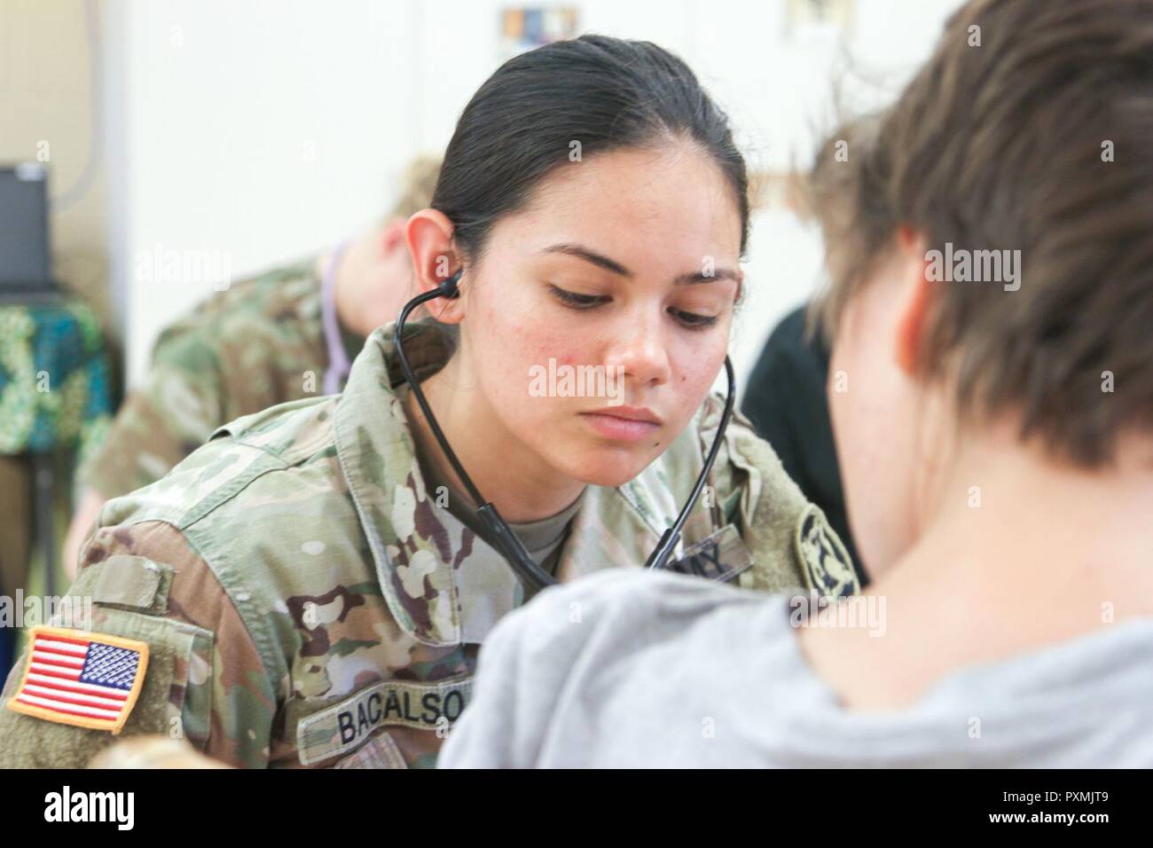 U.S. Army Reserve Pfc. Samantha Bacalso, a medic with the 48th Combat Support Hospital A Co. from Virginia Beach, Virginia checks the pulse of a member of the speical needs community June 16, 2017 on the Island of Kauai, Hawaii during Operation Tropic Care 2017. Tropic Care was a joint service operation that asissted in addressing the Kauai community healthcare needs at no cost while allowing the Army Reserve Soldiers to train on their mission-essential expeditionary tasks. Stock Photo
