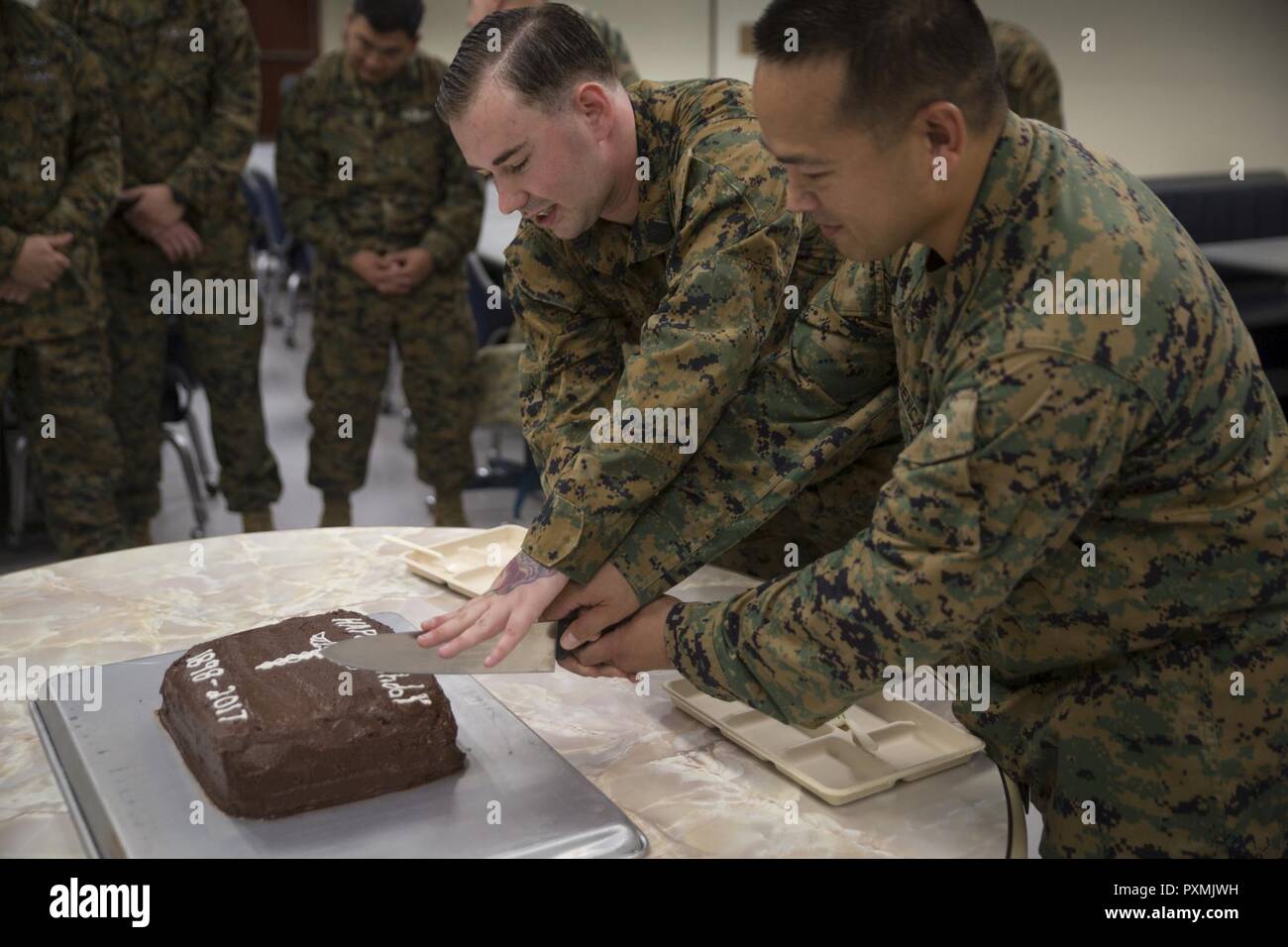 Chief Hospital Corpsman (Fleet Marine Force) Edgar E. Cuenca, right, a preventive medicine technician with Command Element, III Marine Expeditionary Force, and Hospital Corpsman (FMF) Joseph E. Clack, left, a corpsman assigned to 3rd Medical Battalion, 3rd Marine Logistics Group, III MEF, simultaneously cut a ceremonial cake during a celebration for the 119th birthday of the hospital corpsman rate at Camp Mujuk, Pohang, Republic of Korea, June 17, 2017. Marines from Bravo Company, 3rd Law Enforcement Battalion, III Marine Headquarters Group, III MEF and Corpsmen with 3rd Med Bn, 3rd MLG, III M Stock Photo