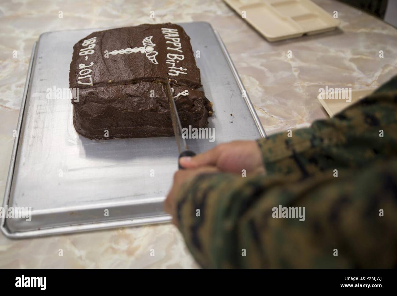 Chief Hospital Corpsman (Fleet Marine Force) Edgar E. Cuenca, a preventive medicine technician with Command Element, III Marine Expeditionary Force, cut a ceremonial cake into squares during a celebration for the 119th birthday of the hospital corpsman rate at Camp Mujuk, Pohang, Republic of Korea, June 17, 2017. Marines from Bravo Company, 3rd Law Enforcement Battalion, III Marine Headquarters Group, III MEF and Corpsmen with 3rd Medical Battaion, 3rd Marine Logistics Group, III MEF came together to celebrate the birthday with a ceremonial cake cutting and birthday message reading from 3rd LE Stock Photo