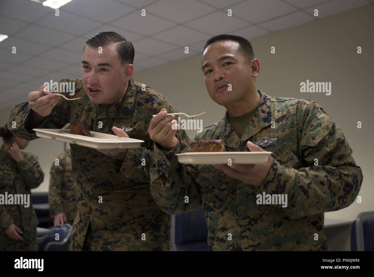 Chief Hospital Corpsman (Fleet Marine Force) Edgar E. Cuenca, right, a preventive medicine technician with Command Element, III Marine Expeditionary Force, and Hospital Corpsman (FMF) Joseph E. Clack, left, a corpsman assigned to 3rd Medical Battalion, 3rd Marine Logistics Group, III MEF, take the first bite of the ceremonial cake during a celebration for the 119th birthday of the hospital corpsman rate at Camp Mujuk, Pohang, Republic of Korea, June 17, 2017. Marines from Bravo Company, 3rd Law Enforcement Battalion, III Marine Headquarters Group, III MEF and Corpsmen with 3rd Med Bn, 3rd MLG, Stock Photo
