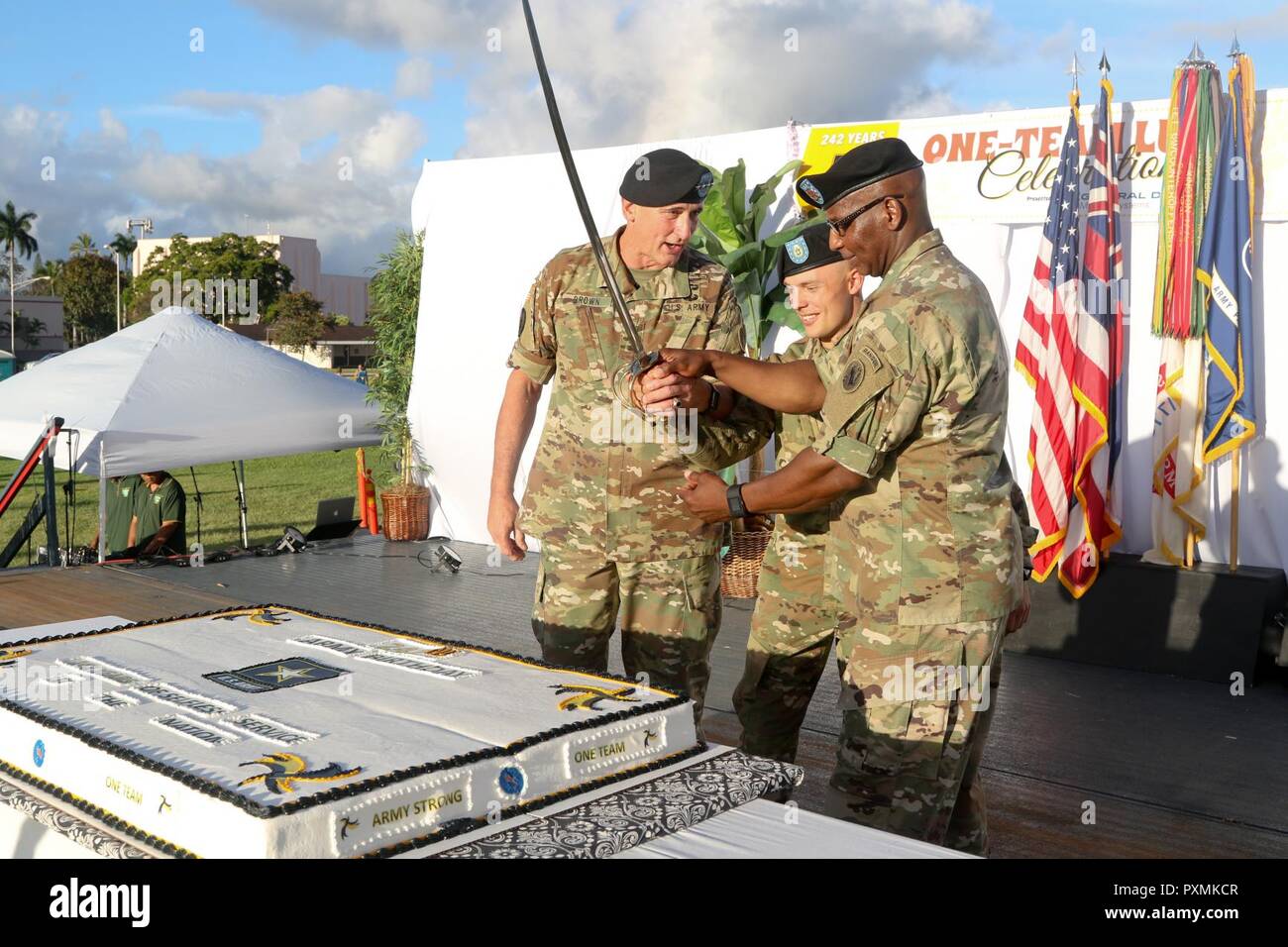 The formal portion of the luau concluded with the traditional cake cutting. Representing the past, present, and future successes of United States Army Pacific was: Gen. Robert B. Brown (left), the command's most senior commissioned officer, who also represented the most senior Army Soldier; Command Sgt. Maj. Bryant Lambert (right), USARPAC's senior enlisted leader; the command's youngest Soldier, Pvt. 1st Class Michael Rankin from the 25th Infantry Division. USARHAW and USARPAC celebrated the Army’s birthday with a luau instead of the more traditional ball. The luau was a fun way of getting So Stock Photo