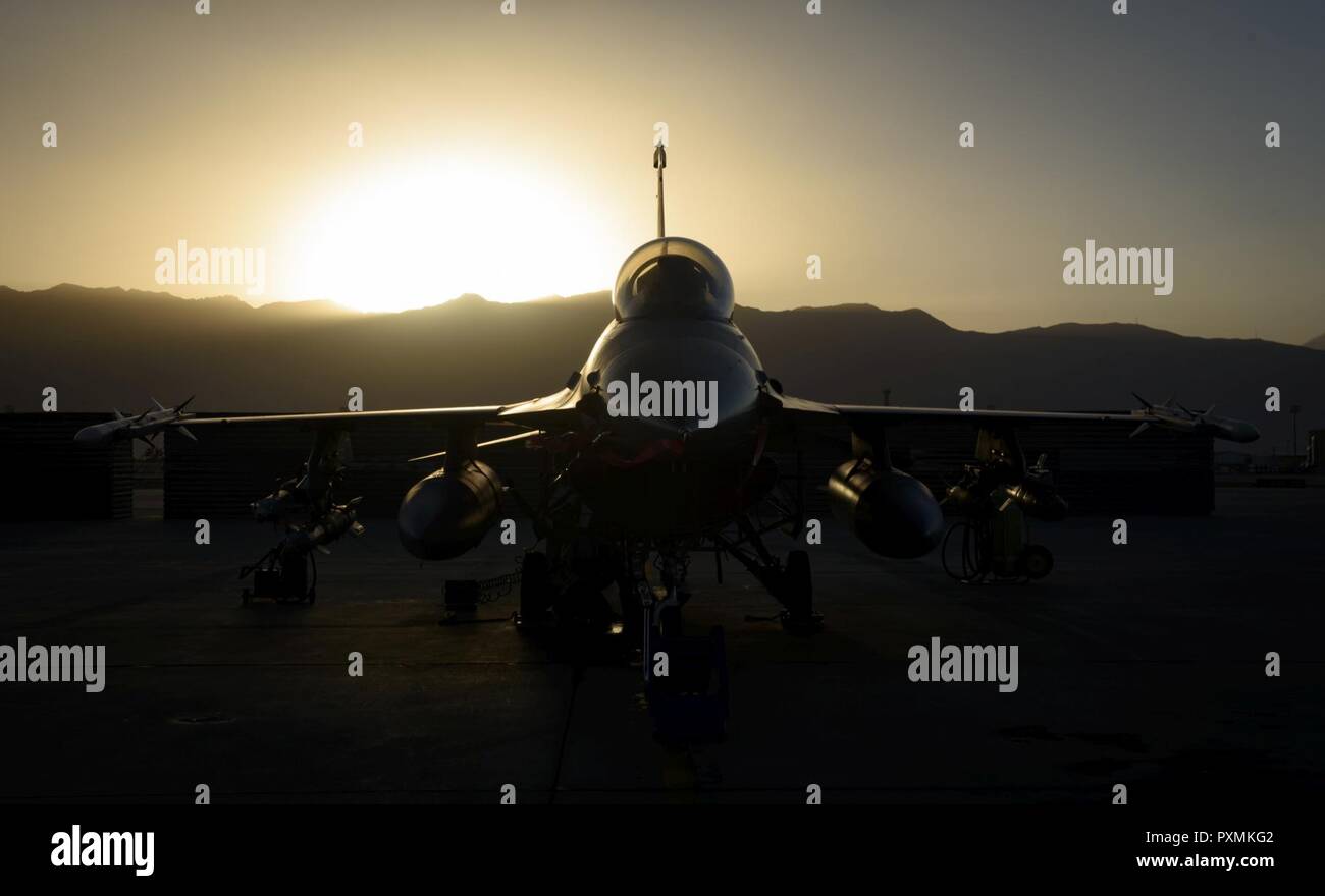 An F-16 Fighting Falcon, belonging to the 555th Expeditionary Fighter Squadron, sits on the ramp as 455th Expeditionary Aircraft Maintenance Squadron Airmen work on it at Bagram Airfield, Afghanistan, June 16, 2017. The 555th EFS, deployed out of Aviano Air Base, Italy, conducts counterterrorism operations which enable Resolute Support’s train, advise, and assist campaign. Stock Photo