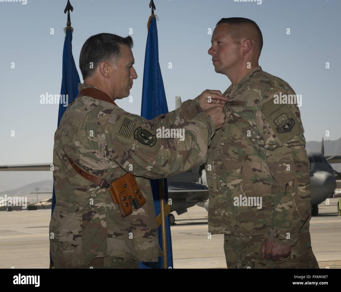 Col. Eric Soto, the outgoing 455th Expeditionary Maintenance Group commander, receives the Bronze Star medal from Brig. Gen. Craig Baker, the 455th Air Expeditionary Wing commander, during the 455th EMXG change of command ceremony at Bagram Airfield, Afghanistan, June 17, 2017. Soto served as the 455th EMXG commander for the past 12 months. Stock Photo