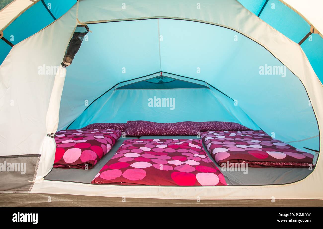 Tent interior with mattresses and purple duvet covers. Stock Photo