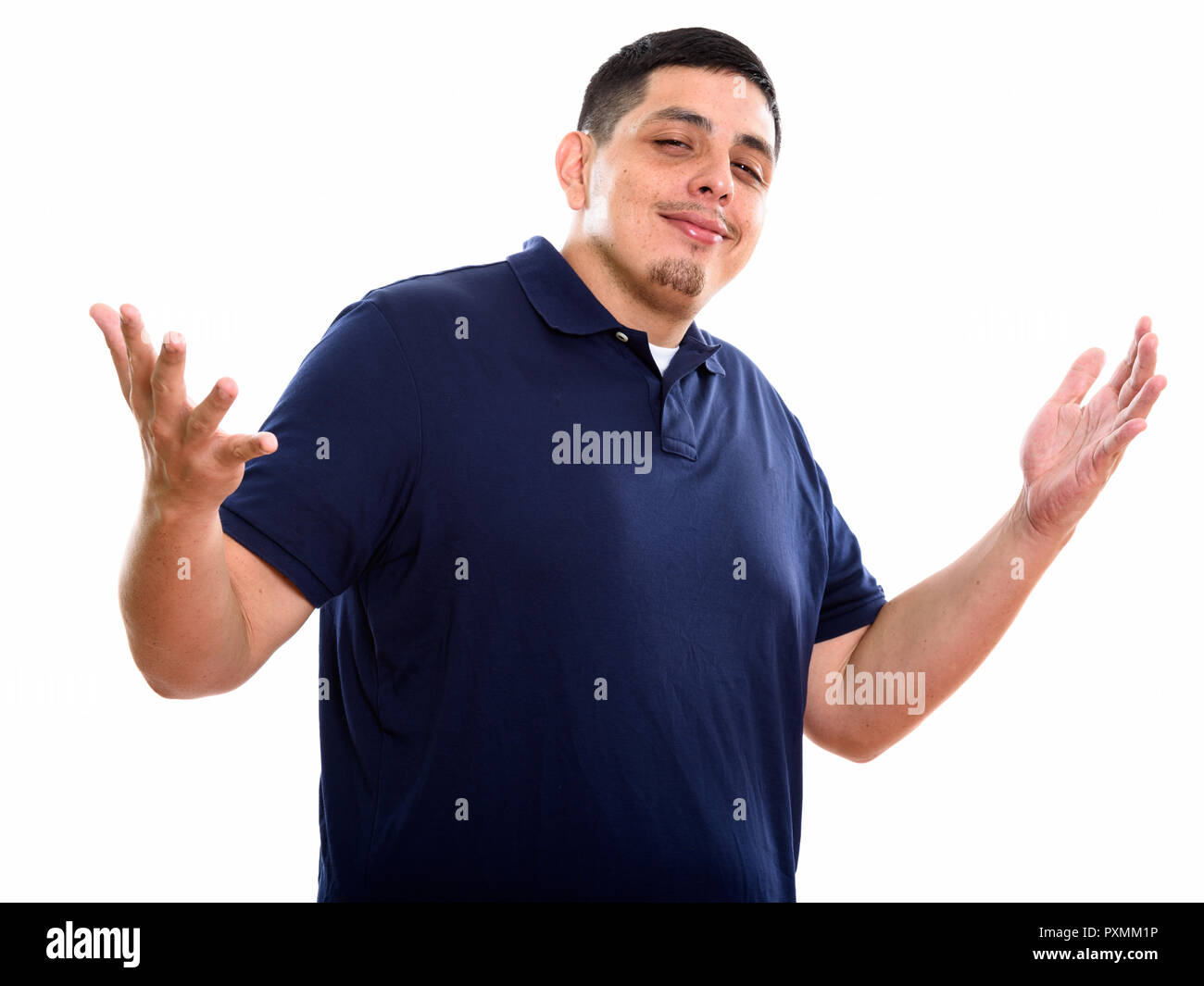 Studio shot of young Hispanic man with both arms raised Stock Photo