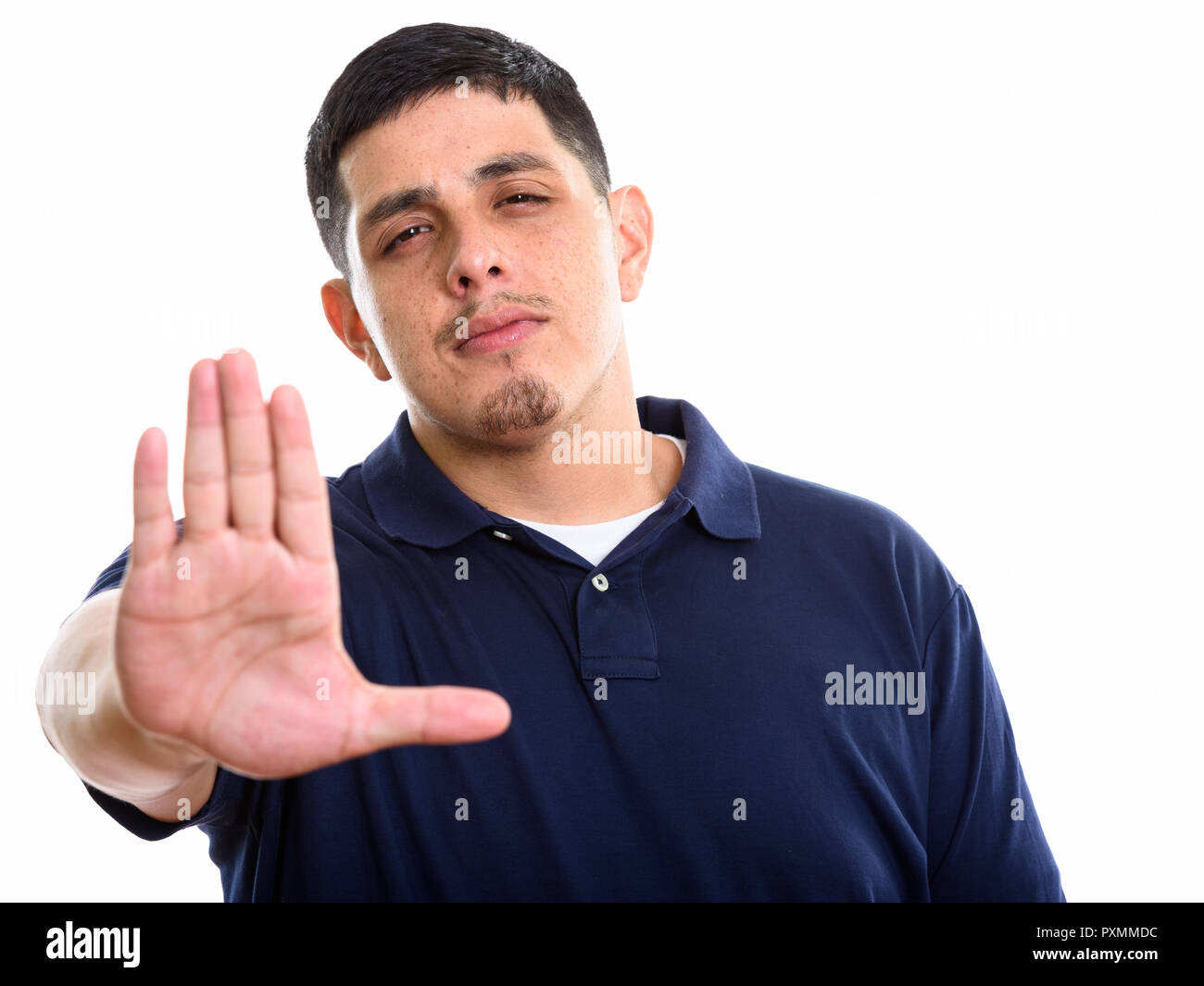 Studio shot of young Hispanic man with stop hand gesture Stock Photo
