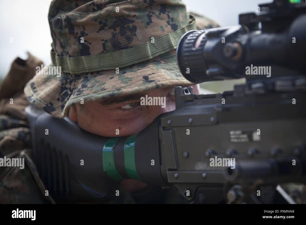 MARINE CORPS BASE HAWAII – Lance Cpl. Cooper Walker, a machine gunner with Kilo Company, 3rd Battalion, 3rd Marine Regiment, looks through his M240B machine gun while conducting gun drills during Exercise Bougainville 1-17.2 at Landing Zone Boondocker aboard Marine Corps Base Hawaii, June 17, 2017. The unit went over procedures and the basics of their roles as infantrymen for Exercise Bougainville, a two-week training exercise to enhance their lethality and effectiveness as a force in readiness. Kilo Co. conducted Military Operation in Urban Terrain training in which Marines practiced clearing Stock Photo