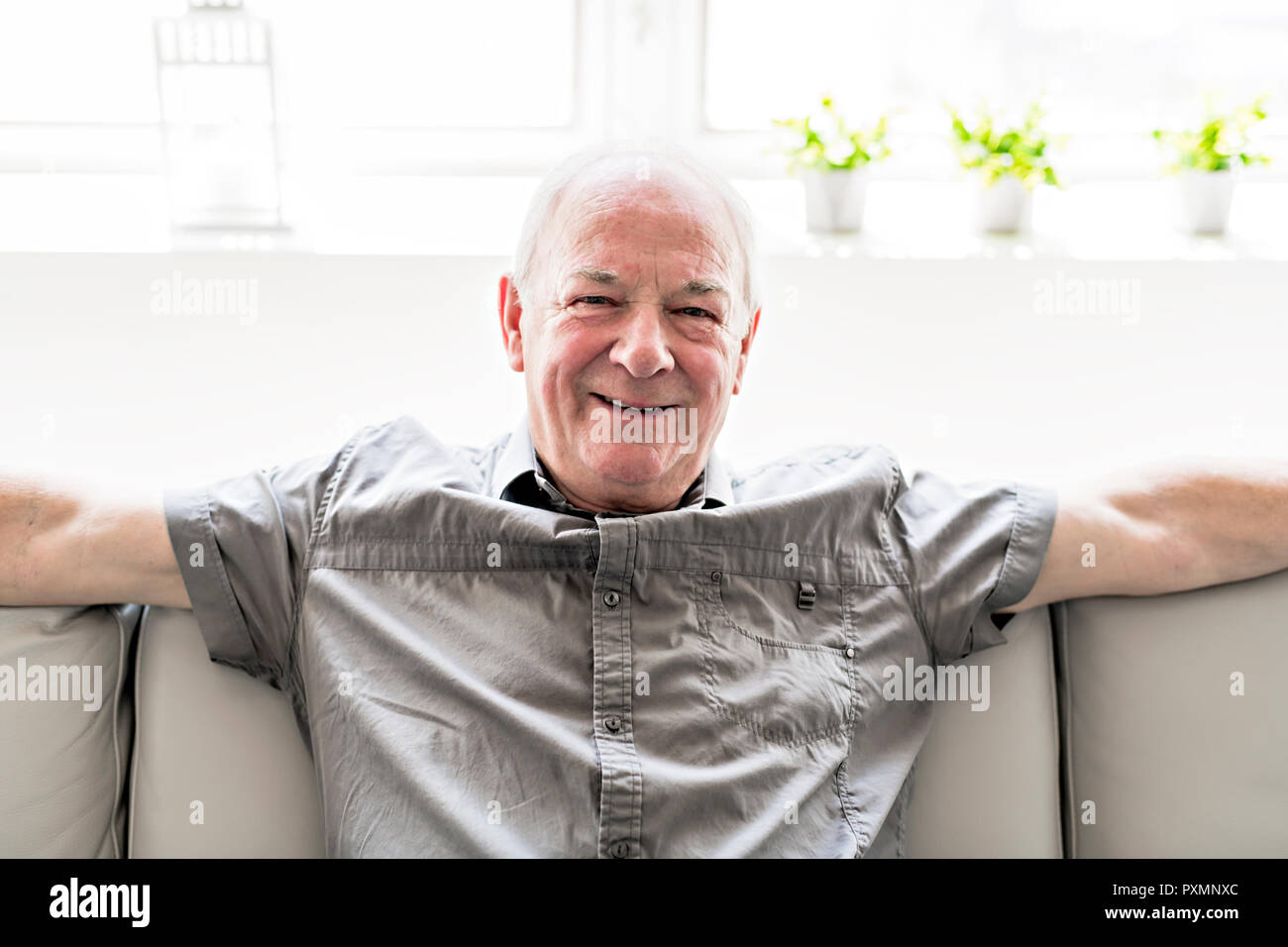 Senior man at home on the sofa Stock Photo