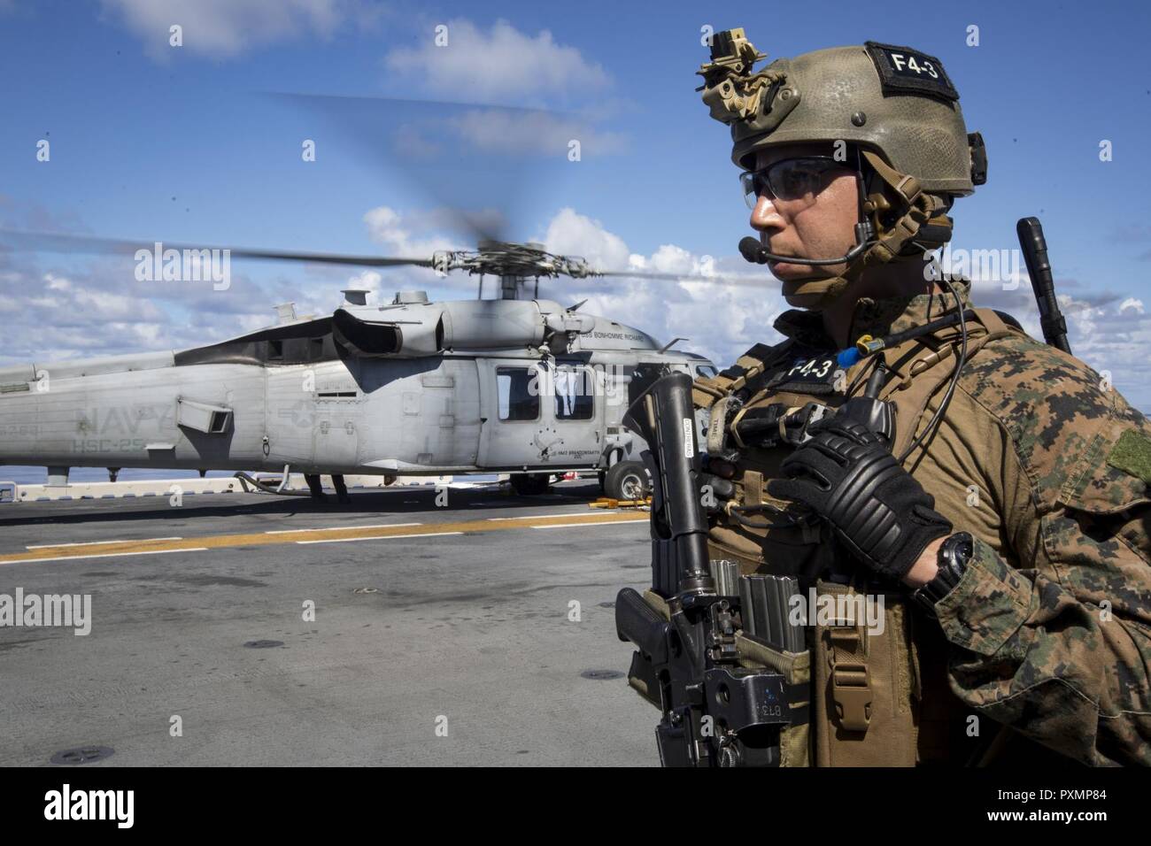 Staff Sgt. Abel Contreras, communications chief with the 31st Marine Expeditionary Unit’s Force Reconnaissance Platoon (FRP), waits to board an MH-60S Sea Hawk helicopter aboard the USS Bonhomme Richard (LHD 6) before launching for vessel Visit, Board, Search and Seizure (VBSS) training, June 15, 2017. During VBSS, Marines with FRP board vessels via rotary-wing aircraft or surface boats in response to a terrorist threat, to interdict pirates and smugglers or to disrupt criminal activity. The 31st MEU partners with the Navy’s Amphibious Squadron 11 to form the amphibious component of the Bonh Stock Photo