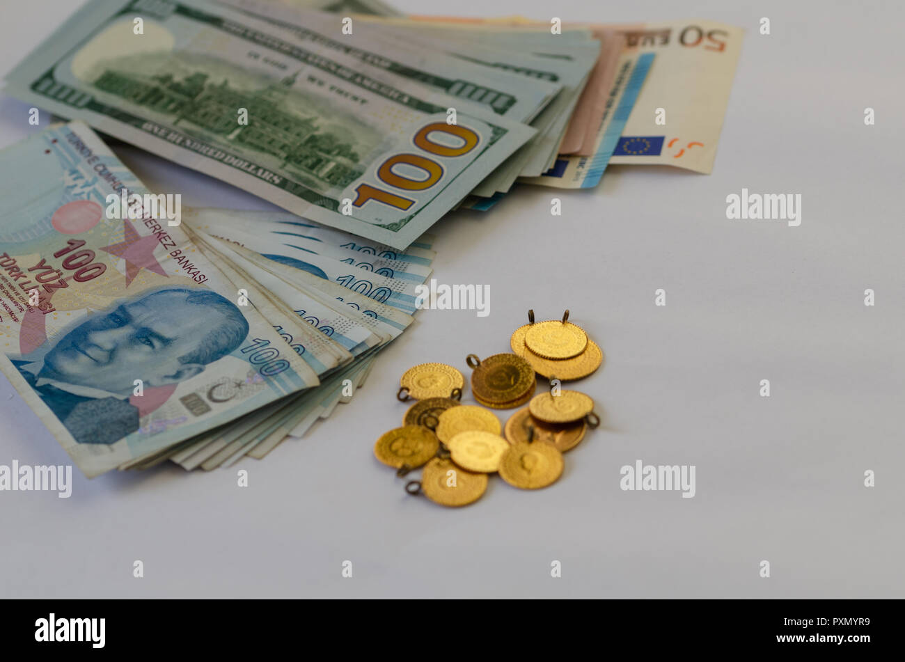 There are gold,dolar,euro and liras banknotes on the white background. Saving money concept. Stock Photo